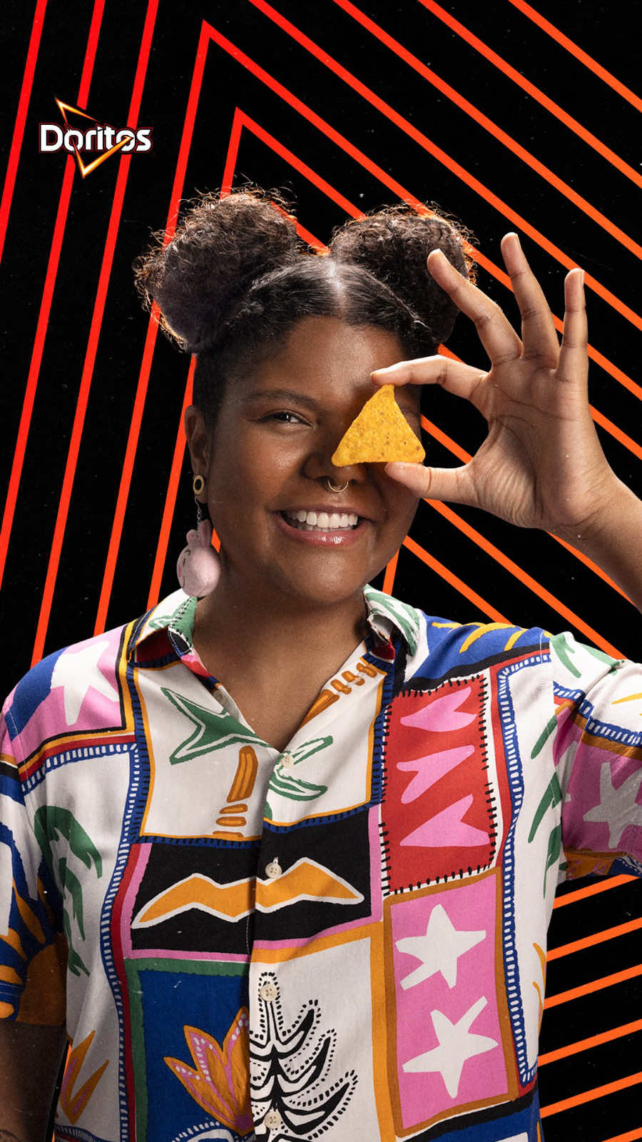 DORITOS®️ e Feira Preta estão junto com Gabrielle, que usa tecnologia para incluir e empoderar com Programa Edumi. DORITOS®️ For the Bold #PraTodosVerem: O filme começa com a imagem de Gabrielle. Ela usa uma roupa branca, estampada. Vemos três imagens estáticas dela em diferentes poses. Nas pontas, ela segura um pacote de DORITOS®️ na mão. Logo depois, a imagem troca e vemos ela segurando uma tortilla de DORITOS®️. Então, um efeito com a marca surge na tela: são vários triângulos vermelhos, com a marca no centro. Eles aparecem rapidamente e desaparecem. Depois, vemos ela caminhando, sorrindo e olhando para a câmera. Então, vemos a câmera se aproximar e, de repente, ela está sentada. Ela usa óculos e olha para a câmera de baixo para cima. Na sequência, vemos ela mexendo no cabelo e, depois, segurando duas tortillas de DORITOS®️. No canto direito, vemos duas imagens de triângulos, com ela no interior, segurando DORITOS®️, como no início do filme. Depois, rapidamente, aparecem imagens que remetem à sua organização: um celular e um computador sendo operados por uma pessoa. Por fim, vemos Gabrielle fazendo sua assinatura na tela, como se riscasse o visor da câmera, na cor vermelha, com um triângulo vazado remetendo ao formato da tortilla DORITOS®️. Por fim, vemos a assinatura do filme. À direita da tela, aparecem três embalagens de DORITOS®️: Sweet Chili, Queijo Nacho e Pizza, respectivamente, os sabores que surgem. À esquerda, há um lettering com a assinatura da campanha: For The Bold.