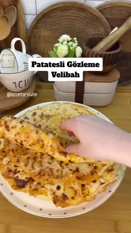 Patatesli Gözleme(Velibah) 📌hamur için; 1 su bardağı süt(ılık)  1 su bardağı su(ılık) 1 paket instant maya 2 yemek kaşığı sıvıyağ 1 tatlı kaşığı şeker 1 tatlı kaşığı tuz 5-5buçuk su bardağı un 📌iç harç; 4-5 orta boy patates  1 soğan 3 yemek kaşığı sıvıyağ 1 tatlı kaşığı salça  1 tatlı kaşığı tuz  Çayım çay kaşığı karabiber, kırmızı toz biber  📌 önce hamuru yoğurup mayalandıracağız. Hamur için süt, su, şeker ve mayayı kaseye alıp 5 dk ön mayalanma yapalım. Sonra sıvıyağ ve tuzu ekleyip unu hafif ele yapışan bir kıvama gelene kadar ekleyip yoğuralım. Yaklaşık 5 buçuk bardak alıyor. İyice yoğurup mayalanmaya bırakıyoruz.(40 dk) 📌İç harcı için patatesleri haşlayalım. Bir tencereye sıvıyağ soğan ve salçayı alıp kavuralım ve haşlayıp ezdiğimiz patatesleri ekleyelim. Bir iki tur çevirip tuzunu ve baharatlarını da atıp karıştıralım ve altını kapatalım.  📌 hamuru mandalina büyüklüğünde bezelere ayıralım.(yaklaşık 10 tane çıkıyor) Soğuyan patatesleri de hamur bezeleri kadar bölüştürüp yuvarlayalım.  📌bezeleri çok az açıp içine patates toplarından koyup kapatalım. Ve merdaneyle yavaş yavaş hafif unlayarak büyütebildiğimiz kadar büyütelim. Servis tabağı büyüklüğünde olursa iyi olur. Sonra ısıttığımız tavada önlü arkalı pişirelim. Pişen tarafına tereyağ sürelim. Ve pişen gözlemelerin üzerine kurumamaları için örtü örtelim. Çocuklar bayılarak yiyor, fazlasını da buzluğa atıyorum. Deneyeceklere afiyet olsun.  #patatesligözleme #velibah #gözleme #börektarifleri #kesfet #tiktok #sunum #patateslibörek #keşfetteyiz 