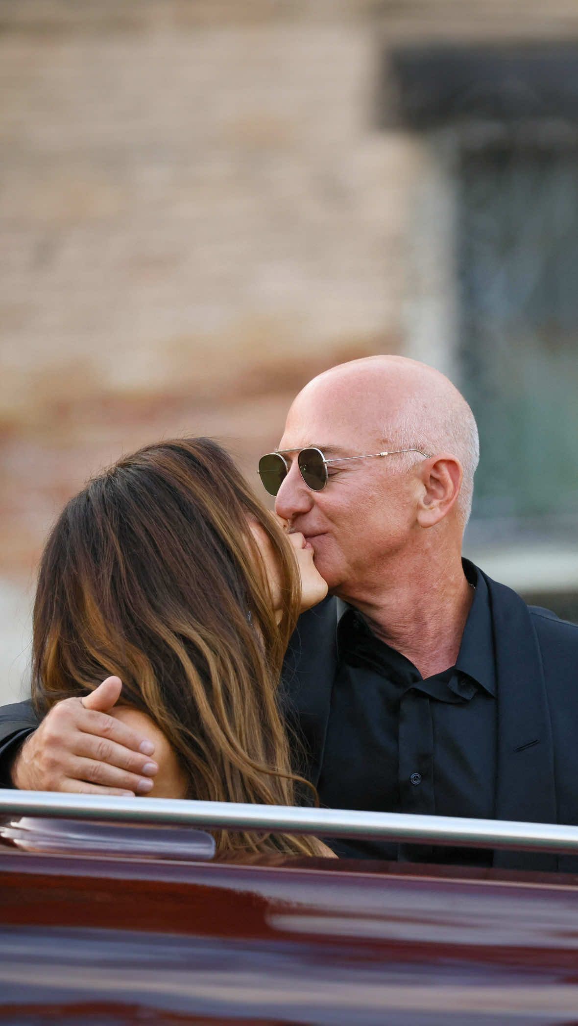 Day 3. Il tema? Pajama party. Un classico senza tempo. Venezia è il palcoscenico di Jeff Bezos e Lauren Sanchez in questi giorni: dopo aver celebrato ieri il loro matrimonio, oggi proseguono i festeggiamenti insieme agli ospiti. Affiatatissimi, complici e sempre pronti a salutare con calore fan e fotografi, i novelli sposi si godono ogni attimo di questa favola. Jeff Bezos in total black, mentre Lauren Sanchez sceglie il rosa nelle tonalità più delicate con un bustier dress firmato Atelier Versace, un altro omaggio alla moda italiana attraverso le sue scelte di stile. L’abito è caratterizzato da un corsetto a cuore strutturato con ricami scintillanti, una silhouette che segna i fianchi e lunghezze in chiffon che donano morbidezza al look, prezioso e femminile. Il tocco di classe? La scritta sulla borsa: “Miss Bezos”. Un dettaglio che vale più di mille parole. [📸 IPA 📹 Getty Images] #whoopsee #jeffbezos #laurensanchez 