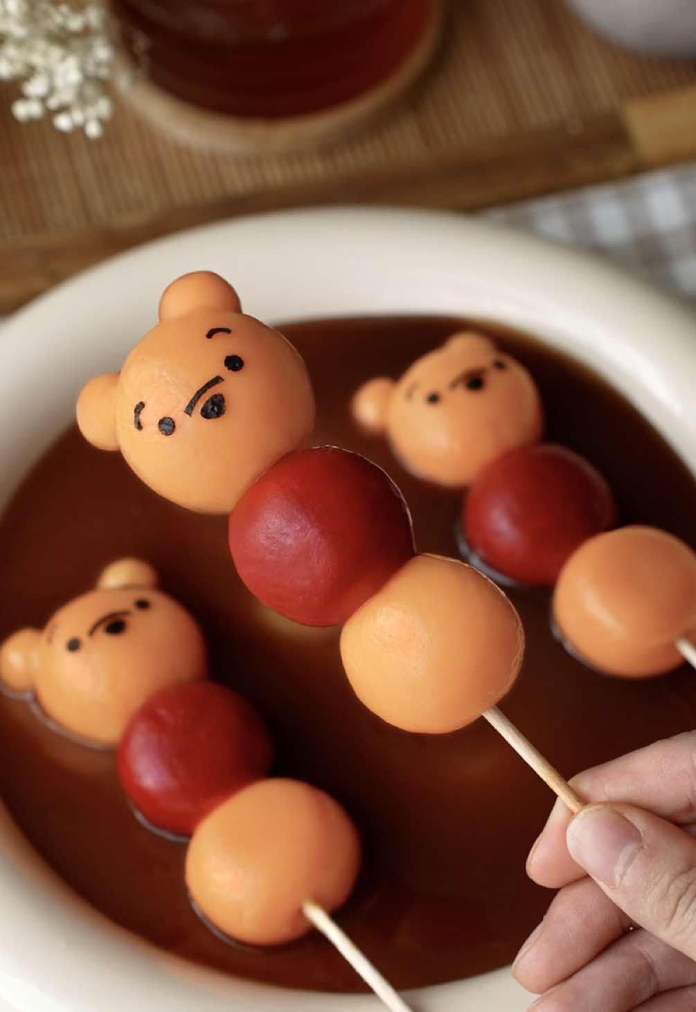 Winnie The Pooh Mitarashi Dango 🍡🐻🍯 I loooove these soft, chewy dangos with the sweet soy glaze!! I used silken tofu which gives the dango a soft and tender texture without being too dense. Also, I turned them into Winnie The Pooh making them even more fun to eat! 🧸 Ingredients Dango: - 100g silken tofu - 100g shiratamako or glutinous rice flour - yellow and red food coloring - roasted seaweed for the face Sauce: - 150ml water - 2 tbsp soy sauce - 2 tbsp mirin - 2 tbsp sugar - 2 tsp cornstarch 1. In a bowl, mix silken tofu and shiratamako until smooth dough forms. 2. Divide the dough with 1/3 for red color and 2/3 for yellow. 3. Roll the yellow dough into smooth balls to form Pooh’s head and gently press two small dango ears on top of each ball. You should have 3 yellow heads, 3 yellow balls and 3 red balls. 4. Gently add the dango balls into a pot of boiling water. When they float, continue boiling for 1-2 minutes and transfer them to a bowl of ice cold water, then drain. 5. Thread the dango onto skewers in this order: one yellow bowl, one red ball and finally one yellow ball with ears on top. 6. Cut tiny bits of nori to make Winnie The Pooh’s face and gently stick them dango. 7. In a small sauce pan, add water, soy sauce, mirin, sugar and cornstarch. Mix well and turn on the heat. Bring to a simmer and stir until thickened. 8. Serve the sauce with the Winnie The Pooh dango and enjoy! 🍡  #mitarashidango #dango #winniethepooh #winniepooh #disney #japanesefood #japanesestreetfood 