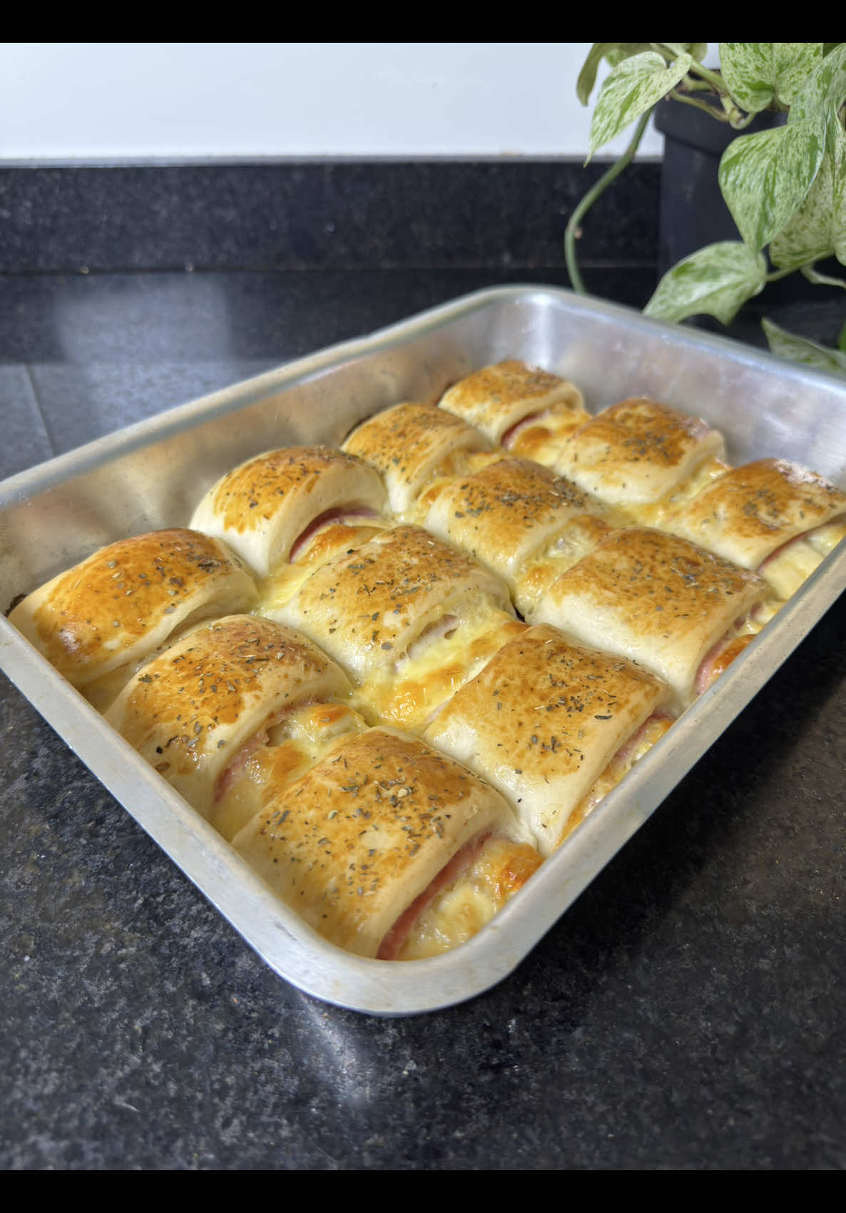 JOELHO DE PRESUNTO E QUEIJO 🧡 INGREDIENTES • 500g de farinha de trigo (vá colocando aos poucos, pode variar conforme a marca) • 10g de fermento biológico seco • 300ml de água morna • 100ml de óleo • 2 colheres de sopa de açúcar • 1 colher de chá de sal RECHEIO (a gosto) • Presunto • Mussarela • Requeijão MODO DE PREPARO NO VÍDEO A massa precisa crescer duas vezes: 	1.	A primeira fermentação é logo após sovar a massa. 	2.	A segunda é depois de rechear e modelar os salgados. Aqui rendeu 23 unidades! #salgado #receita #receitas #receitadesalgado #joelho #enroladinho #enroladinhodepresuntoequeijo