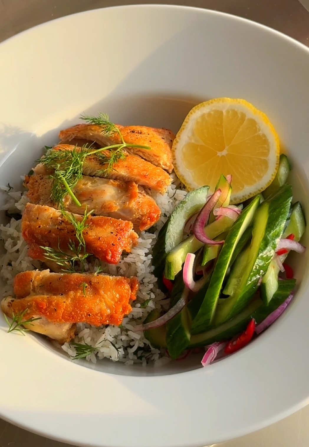 🔫 Crispy chicken, herby rice & quick pickled cucumber salad 🥒🍗 One of my favorite weeknight dinners when I don’t feel like thinking too much. Crispy, juicy, fresh and seriously easy to make. Inspired by @mob  RECIPE (serves ~3) • 4 chicken thighs (boneless) • 300g basmati rice • 1 cucumber • 1 small red onion • 1 small red chilli • 2 tbsp white wine vinegar • 2 tsp sugar • Fresh parsley, dill & mint • 1 lemon • 1 shallot • Salt & pepper HOW TO 1) Start with the pickle: slice cucumber, onion & chilli. Mix with vinegar, sugar & a pinch of salt. Set aside. 2) Season chicken thighs with salt & pepper. Sear in a pan for 15 min until golden & cooked through. I like cook 1 side for 10 minutes to get that nice crispiness. 3) Cook basmati rice. Steam for a few min off heat. 4) Optional for extra flavour: dice shallots & herbs. Sauté shallots in leftover chicken fat. 5) Mix rice with shallots, herbs, and some lemon juice. 6) Slice the chicken, plate it over the rice. Add that cucumber salad. Top with more herbs & a lemon wedge. I drop great recipes like this every week - follow for more & share this one with someone who would like it 😎  Enjoy! #EasyRecipe #highprotein #chickenandrice #pickle #healthycooking