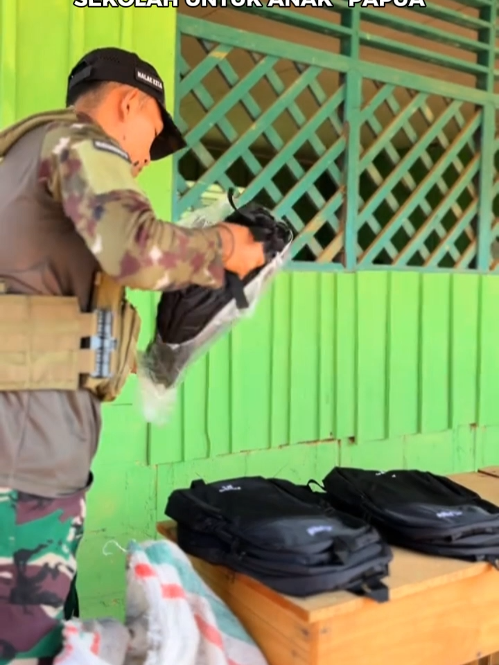 berbeda dengan opm yg merampas, para tni berbagi keperluan sekolah untuk anak