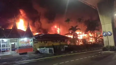Kebakaran Melanda Pasar Taman Puring di Jakarta Selatan Pada hari Senin, 28 Juli 2025, sekitar pukul 17.50 WIB, telah terjadi kebakaran yang melanda Pasar Taman Puring yang terletak di Jl. Kyai Maja, Kelurahan Kramat Pela, Kebayoran Baru, Jakarta Selatan. Peristiwa ini mengundang perhatian besar masyarakat dan menjadi sorotan karena dampaknya yang signifikan. Hingga saat ini, kerugian materiil akibat kebakaran masih dalam proses penaksiran. Dilaporkan tidak ada korban luka dalam insiden ini. Dua orang saksi telah memberikan keterangan mengenai kejadian kebakaran ini. Menurut saksi E-N, saat akan menuju masjid di dalam pasar untuk sholat Maghrib, ia melihat asap hitam yang berasal dari kios pakaian di Blok E dan F. Ia kemudian melaporkan bahwa api dengan cepat membesar. Bersama temannya, E-N mencoba memadamkan api menggunakan alat pemadam api (APAR) yang ada di pasar, namun usaha tersebut tidak membuahkan hasil. Saksi lain, K-S, mengungkapkan bahwa setelah menerima kabar dari anaknya, D-N, yang masih berada di dalam ruko, ia segera menuju ke Taman Puring dan mendapati ruko-ruko telah terbakar dan tidak ada barang dagangan yang bisa diselamatkan. Ia mencatat bahwa total toko di Taman Puring kurang lebih berjumlah 724 ruko. Polisi masih Mengumpulkan keterangan untuk investigasi lebih lanjut terkait penyebab kebakaran dan upaya penanganan yang akan dilakukan.