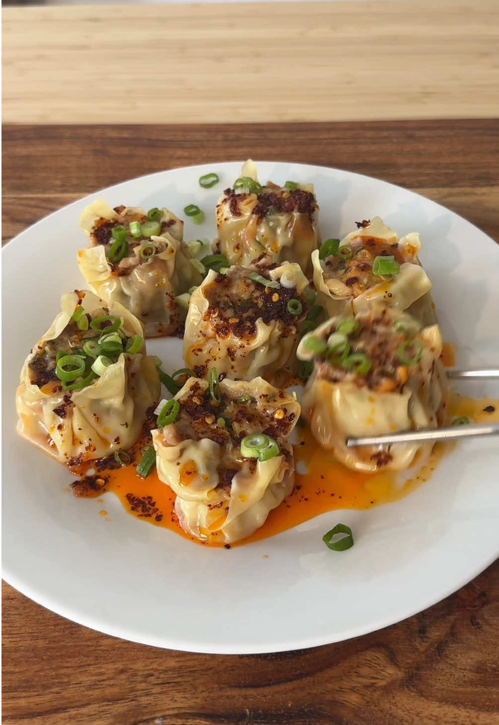PORK SIU MAI WITH AIR-FRYER CHILLI OIL 🥟🔥🥢 This classic yum cha favourite is all done in one appliance! The @Ninja Kitchen Australia Combi 14-in-1 Multicooker steams the siu mai to perfection, then switches to air fryer mode to make the chilli oil. DUMPLING FILLING - 600g fatty pork mince - ½ carrot, finely grated - 4 dried shiitake mushrooms, rehydrated and chopped - 4 spring onions, finely chopped - 2 tbsp oyster sauce - 1 tbsp light soy sauce - ½ tbsp sesame oil - ½ tsp ground white pepper - 1½ tbsp cornstarch TO WRAP & COOK - 35 large wonton wrappers - Spray oil - Spring onion, to serve AIR-FRYER CHILLI OIL - 3 tbsp Korean chilli flakes - 1 tbsp spicy chilli flakes - 1 cinnamon stick - 2 bay leaves - 2 star anise - 1 tsp salt - ½ tsp sugar - 500ml neutral oil To make the filling, mix all dumpling ingredients in a bowl until sticky and well combined. To wrap, place a wrapper over your thumb and index finger, add a heaped tsp of filling, then press down so the wrapper hugs the filling. Tap the base to flatten and repeat. Pour 1 cup water into the Ninja Combi’s bottom tray, spray the top tray with oil, and place the siu mai with space between each. Steam on Combi Steam setting for 10–15 mins. Meanwhile, mix all chilli oil ingredients in a heatproof dish and air fry at 150°C for 10–12 mins until aromatic. Serve siu mai with a drizzle of chilli oil and spring onion on top. #AD #NinjaKitchenAU #PorkSiuMai #ChilliOil #Dumplings #SteamedDumplings #AirFryerChilliOil #Airfryer 
