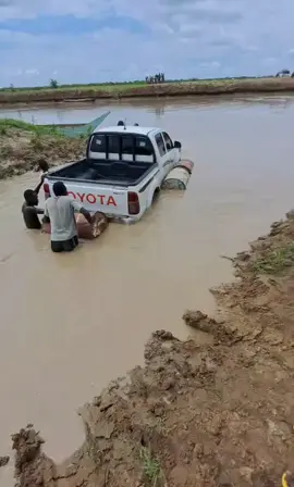 educative-An impressively creative example of local innovation out of necessity. A Toyota Hilux pickup is being converted into a makeshift float by attaching empty oil drums to its sides. This is likely being done to cross a flooded river or seasonal water body where no bridge or ferry is available by making use of empty buoyant barrels to prevent the truck from sinking essentially turning it into a pontoon raft.From the muddy banks and the collective teamwork, this setting indeed suggests a rural or semi-remote area  very typical in South Sudan, parts of Ethiopia, Mozambique, or even Zambia, where improvised solutions are common during the rainy season when roads vanish into floodwaters.Such methods show resilience and technical ingenuity in underserved regions and community collaboration, as seen by people guiding and stabilizing the vehicle in water.A workaround to poor infrastructure, where bridges or proper ferries are absent.