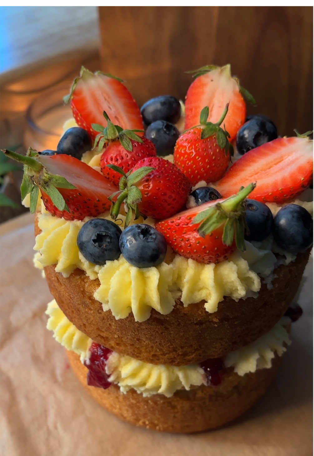 Baking therapy 🍰 A little rustic, a lotta love 🍓✨ Victoria sponge made from scratch, and a slight buttercream flop…let’s ignore that😮‍💨 here’s the full recipe👇🏽 For the sponge cakes:  200g unsalted butter, softened 200g caster sugar 4 medium eggs 200g self-raising flour 1 tsp vanilla extract 1–2 tbsp milk (only if needed to loosen) Instructions: Grease and line the bottoms of your tins (I used 5 inch tins). Preheat oven to 180°C Beat butter and sugar together for 3–5 mins until pale and fluffy. Add eggs beating well between each. Sift the self-raising flour and gently fold it in with a spatula or on low speed. Add vanilla and a splash of milk only if needed the batter should be thick but just drop off a spoon. Divide evenly between tins Level the tops and tap the tins lightly on the counter to remove big air bubbles. Bake for 30-35 minutes, or until golden and a skewer comes out clean. Cool in tins for 10 mins, then turn out onto a wire rack and let them cool completely before assembling. For the cream filling:  200ml double cream (cold) 100g unsalted butter (room temp but not too soft) 150g-170g icing sugar, sifted  1 tsp vanilla Whip the butter and icing sugar together until pale and fluffy (5-8 min)  Separately whip the cream in a cold bowl to firm peaks, stop before it turns grainy. It should look thick and hold peaks when you lift the whisk. Fold in the whipped cream gently but fully into the butter mixture. If it looks too soft, chill it for 15–30 mins, then rewhip for 10 seconds.  Chill to Set: Once assembled with the sponge, pop the whole cake in the fridge for 30–60 mins before slicing. #baking #bakingtherapy #cake #cakedcorating 