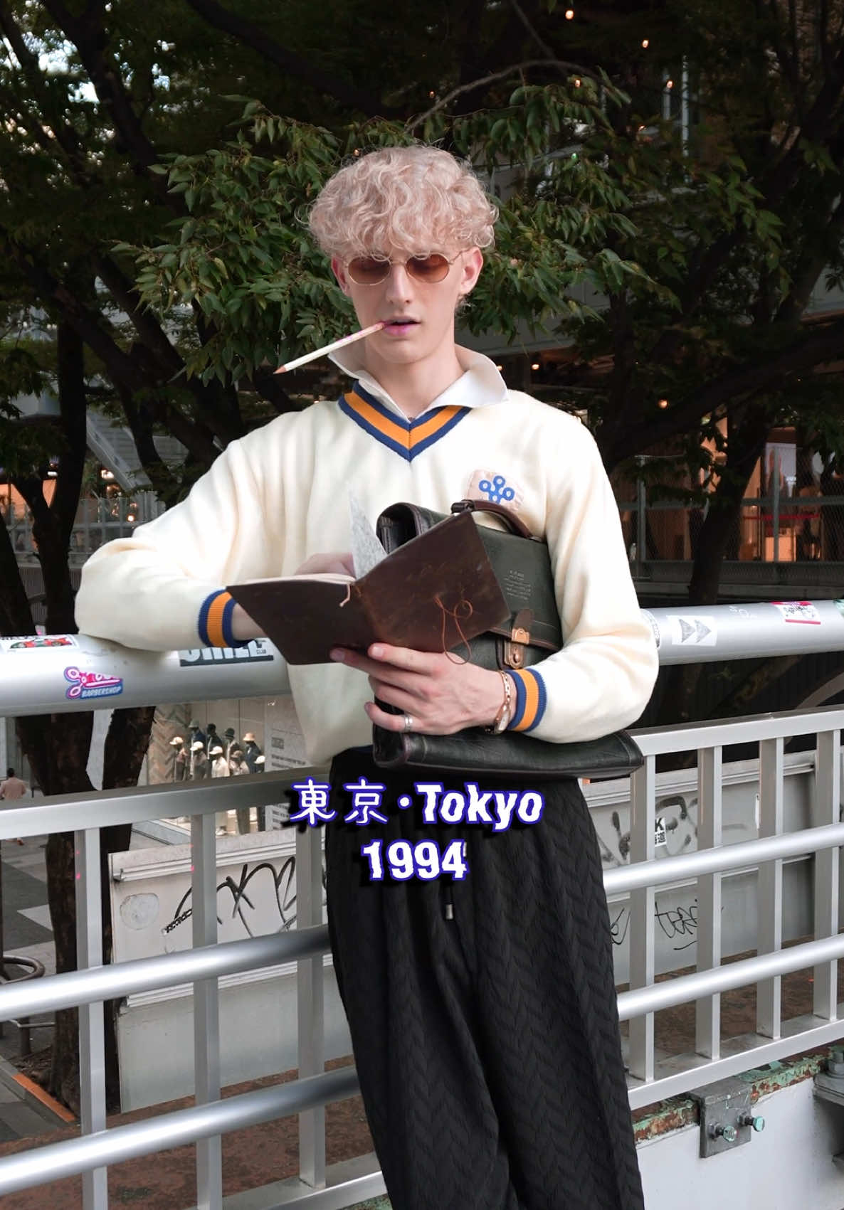 Great Student @Im_kyle_metcalf, Tokyo, 1994. Fashion: - Sweater: Cream-colored V-neck sweater with navy and mustard striped ribbing on the collar, cuffs, and hem. Small emblem on the left chest with the word “大阪”, (Osaka). - Shirt: open-collared shirt in a matching cream tone. - Pants: Loose, wide-leg black pants with a quilted texture and elastic waistband with drawstrings. - Footwear: black Converse sneakers, adding a casual and slightly grunge element. - Accessories: Slim rectangular sunglasses with brown lenses, adding a retro 70s/early 2000s street touch. Music: “99 No Uta”, Satoko Yamano, 1995. Anime: “Great Teacher Onizuka”, 1999.  #citypop #japan 
