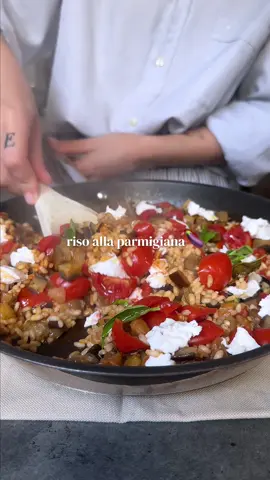 Un mix di sapori che non può che essere vincente✨ Questo piatto sa proprio d’estate ed è facilissimo da preparare, provatelo💖 —— RISO ALLA PARMIGIANA🍆 —— INGREDIENTI X2 PERSONE👩🏼‍🍳 1 melanzana media 1 spicchio d’aglio 20 pomodorini datterino 160 g di riso originario 1 cucchiaino di concentrato di pomodoro 5 o 6 foglie di basilico Q.b. olio evo Q.b. sale 1 mozzarella vegetale —— PROCEDIMENTO🍳 1. Taglia la melanzana in cubetti di circa 1 o 2 cm e mettila a cuocere in padella con 3 cucchiai d’olio e uno spicchio d’aglio. Condiscila subito e lasciala rosolare a fiamma media, rigirandola spesso per non bruciarla. 2. Nel frattempo, taglia in 4 i pomodorini. 3. Quando la melanzana comincia ad essere morbida, unisci in padella anche i pomodorini e il riso. Mescola velocemente e scalda per qualche istante. 4. Copri quindi con acqua bollente (il doppio del volume del riso, perciò se avrai usato 1 bicchiere di riso dovrai usarne 2 d’acqua, per esempio), e scioglici il concentrato di pomodoro.  5. Condisci con due foglie di basilico, un pizzicone di sale, copri col coperchio e lascia cuocere con la fiamma al minimo per il tempo di cottura indicato sulla confezione del riso. 6. A fine cottura, l’acqua sarà del tutto assorbita e potrai completare con la mozzarella spezzettata in superficie, altro basilico fresco e un giro d’olio evo a crudo. —— Se vuoi cercare altre mie ricette, vai su www.mrsveggy.it —— #ricettevegetali #ricettefacili #parmigianadimelanzane #onepotrice 