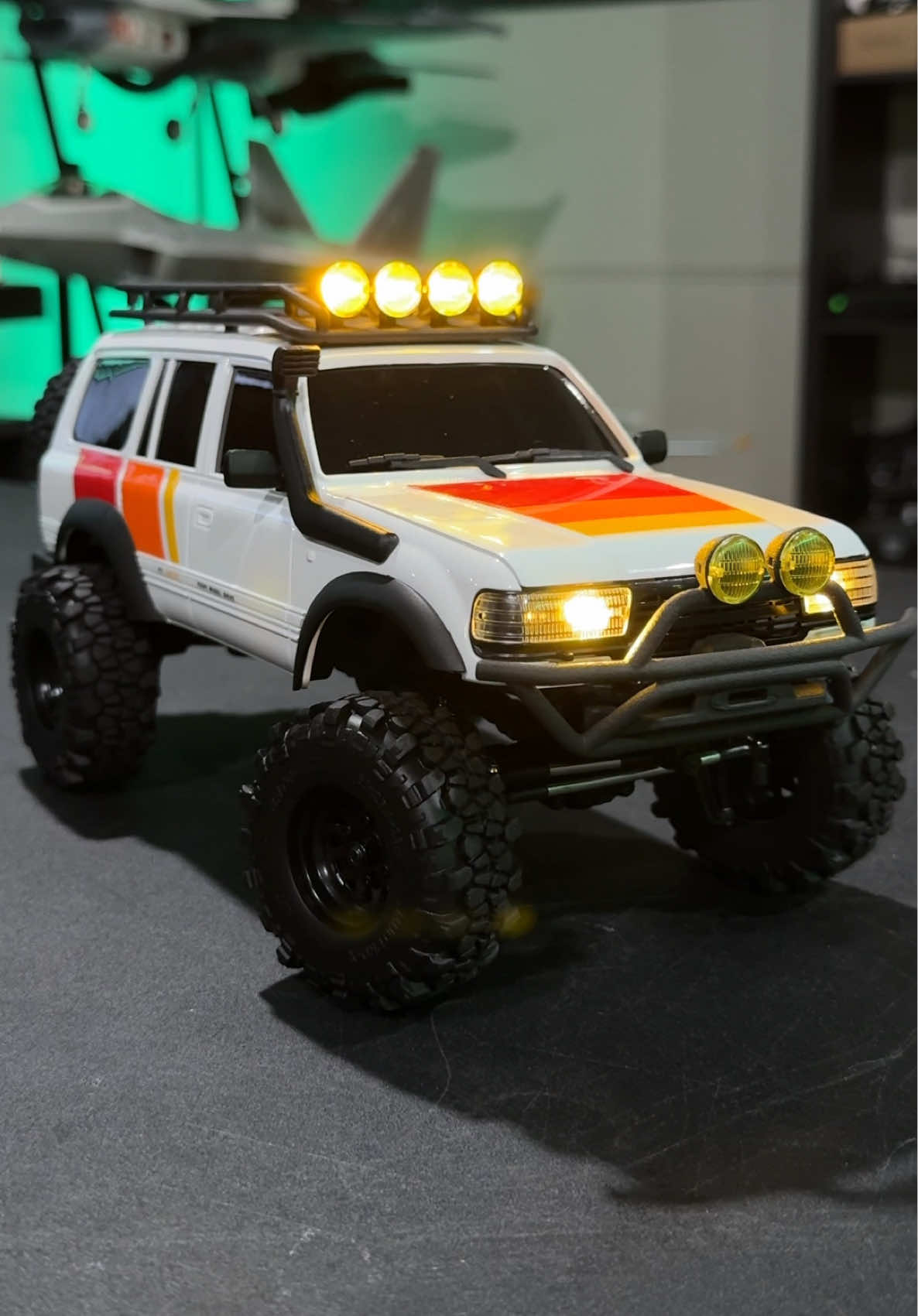 This is the brushless LC80 1/18 scale from @FairRCHobby! This is a mod that features a3200KV brushless motor, tri color livery that I love, a Rhino bumper with light buckets, sterile wheels with brass wheel weights, and Mud Pro-X tires that are super knobby! It looks absolutely fantastic. #rccrawler #radiocontrol #remotecontrol #rccrawling #landcruiser #rc #rchobby