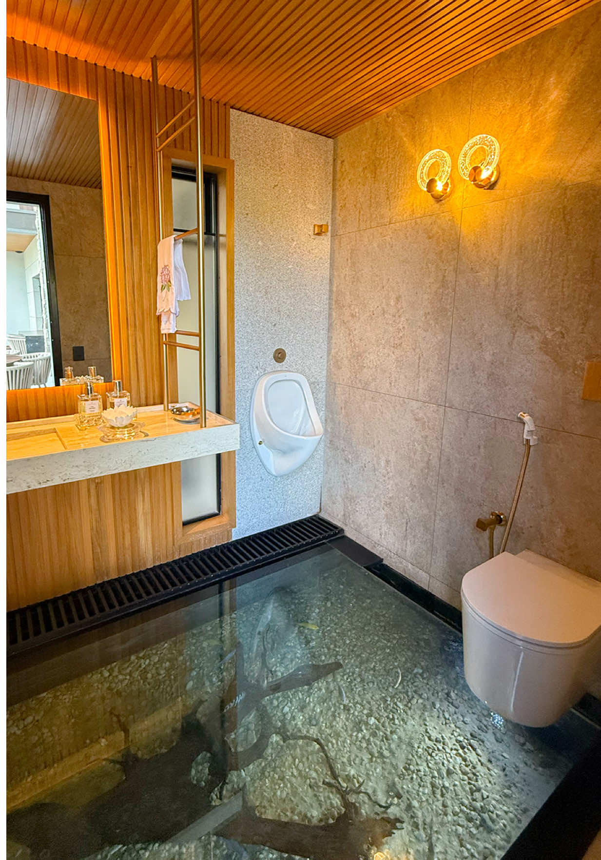 Lavabo Maldivas // Quando o refúgio é sensorial Como nas Maldivas, o inesperado é parte da paisagem. O espelho d’água invade o interior, e o lavabo se transforma em aquário contemplativo. Travertino rústico, teto de madeira e iluminação indireta para um ambiente ainda mais convidativo. Até o sifão desaparece. Como deve ser num refúgio à la Maldivas. #psj #psjarquitetura #arquitetura #goiania #lavabo