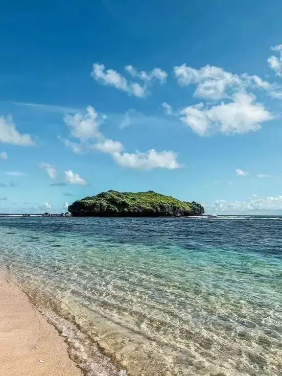 PANTAI SADRANAN di Gunungkidul  Pantai Sadranan adalah salah satu destinasi wisata pantai yang terletak di Kabupaten Gunung Kidul, Yogyakarta. Dikenal dengan keindahan pasir putihnya, air laut yang jernih, dan ombaknya yang relatif lebih tenang dibandingkan pantai-pantai lain di sekitarnya. Lokasi dan Akses Pantai Sadranan berada di Dusun Pulegundes II, Desa Sidoharjo, Kecamatan Tepus, Gunung Kidul. Letaknya berada di antara Pantai Krakal dan Pantai Indrayanti. Meskipun beberapa akses jalannya mungkin masih belum sepenuhnya mulus, pantai ini mudah dijangkau dari pusat kota Yogyakarta dengan waktu tempuh sekitar 2 jam. Daya Tarik Utama dan Aktivitas  * Snorkeling: Air lautnya yang jernih dan ombaknya yang tenang menjadikan Pantai Sadranan tempat yang ideal untuk snorkeling. Pengunjung dapat menikmati keindahan terumbu karang dan berbagai jenis ikan yang hidup di bawah laut. Peralatan snorkeling dapat disewa di lokasi dengan harga terjangkau.  * Kano: Selain snorkeling, tersedia juga penyewaan perahu kano bagi mereka yang ingin menjelajahi perairan di sekitar pantai.  * Bermain Air dan Bersantai: Pasir putihnya yang lembut dan airnya yang tenang sangat cocok untuk berenang, bermain air, atau sekadar bersantai di tepi pantai sambil berjemur.  * Camping: Pantai Sadranan juga menyediakan area khusus untuk berkemah. Pengunjung dapat menyewa tenda untuk merasakan sensasi bermalam di pinggir pantai dan menikmati keindahan matahari terbit serta terbenam.  * Menikmati Matahari Terbit dan Terbenam: Pantai ini menawarkan pemandangan matahari terbit dan terbenam yang memukau. Waktu terbaik untuk menikmatinya adalah sekitar pukul 06.00 pagi untuk matahari terbit dan antara pukul 16.00-18.00 sore untuk matahari terbenam.  * Upacara Adat Nyadran: Nama 
