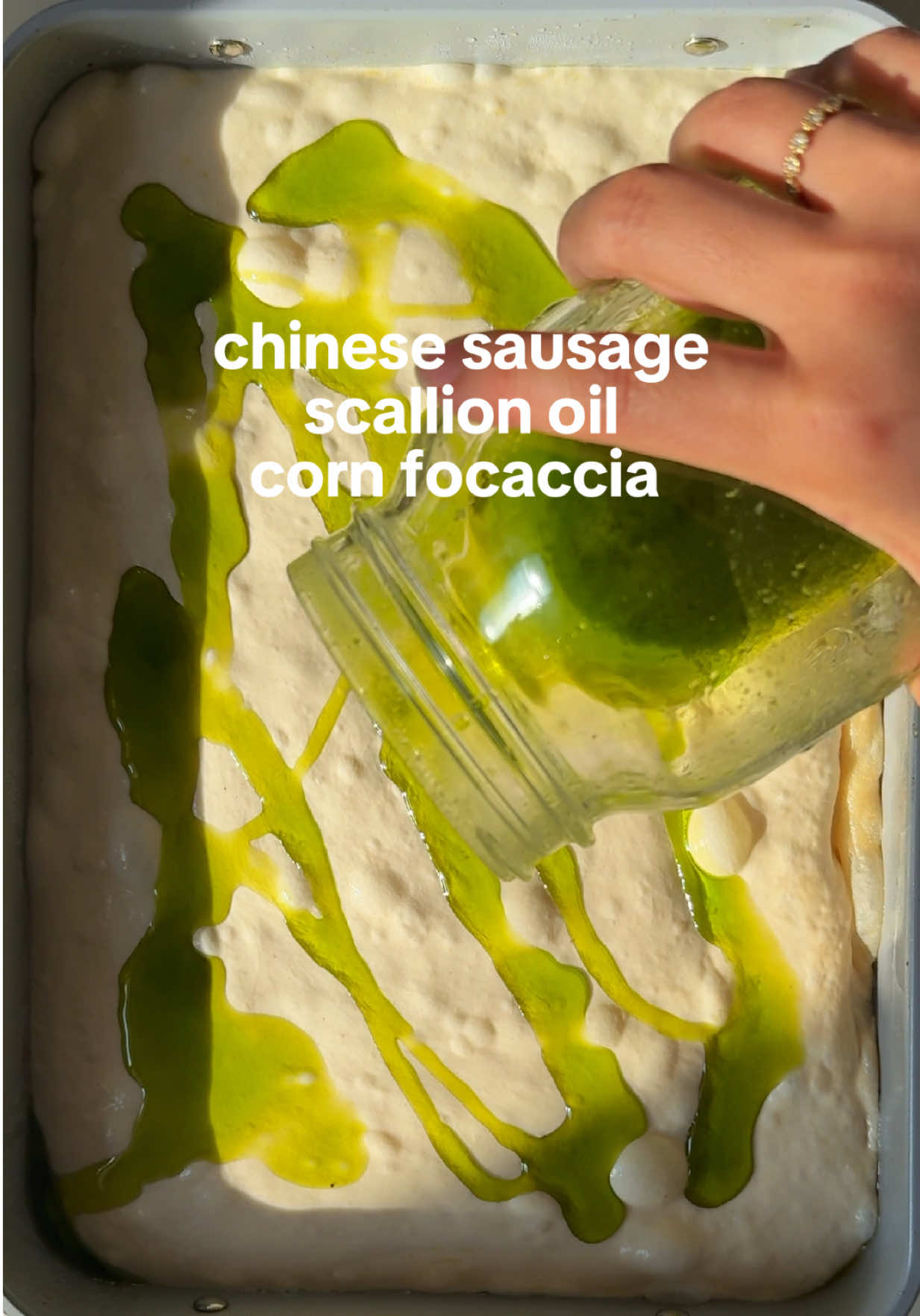 breakfast focaccia for my savory queens!!!! 🧅🌭🌽✨ —recipe— •dough: in a large bowl, mix 500g bread flour, 5g active dry yeast, and 500g water until no dry spots remain. add 10g kosher salt and 30g olive oil, and stir until you get a wet, sticky dough. cover and rest for 15 minutes. •stretch & fold: gently stretch one side of the dough upward and fold it over itself. rotate the bowl and repeat all the way around. cover with a damp towel between rounds. do this 3 more times every 30 minutes. •bulk fermentation: cover tightly and refrigerate for 24 hours. the dough should puff up and get jiggly. •scallion oil: blend 1 bunch scallions, ½ cup olive oil, and 1 tsp salt until smooth. strain through a fine mesh sieve or cheesecloth. reserve the oil and save solids for later use. •pan proof: generously oil a 9x13 pan. carefully transfer the cold dough into the pan, preserving as much air as possible. drizzle scallion oil on top and let rise at room temp for 4–5 hours, until puffy and jiggly. •dimple + top: with oiled fingertips, gently press dimples all over the dough. then scatter thinly sliced lap cheong (Chinese sausage), sweet corn, black sesame seeds, and flaky salt on top. •bake: preheat oven to 450°F. bake for 20–25 minutes, until golden brown and crisp on the edges. cool in the pan for 10 minutes before enjoying. finish with fresh sliced scallions before serving. #focaccia #recipesoftiktok #asianbreakfast #corn #scallionpancake 