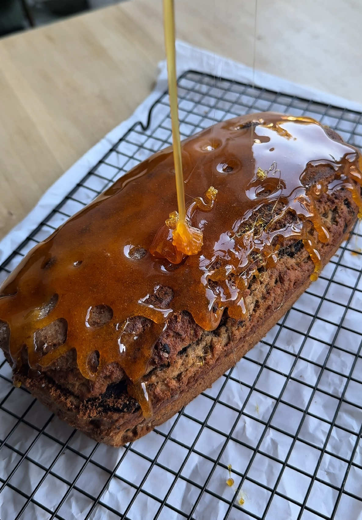 Budín de banana y chocolate con caramelo crocante! Un budín húmedo, lleno de sabor, con pedacitos de chocolate, nueces… ¡y un caramelo crocante por arriba que lo lleva a otro nivel! Ingredientes Para el budín: - 3 huevos - 90 g de azúcar blanca - 90 g de azúcar negra - Un chorrito de esencia de vainilla - 100 ml de aceite - 1 a 2 bananas maduras pisadas  - 300 g de harina leudante - 50 g de nueces picadas - 50 g de chocolate picado Para el caramelo: - 100 g de azúcar (aprox.)  Paso a paso 1- En un bowl, mezclá los huevos con el azúcar blanca y el azúcar negra. La azúcar negra le va a dar un sabor más intenso y una humedad espectacular. 2- Agregá un chorrito de esencia de vainilla y el aceite. 3- Sumá las bananas pisadas y mezclá hasta integrar. 4- Tamizá la harina leudante sobre la mezcla e incorporá con movimientos envolventes. 5- Agregá las nueces picadas y el chocolate en trozos. 6- Volcá la mezcla en una budinera con papel manteca en la base y llevá a horno precalentado a 180 °C por aproximadamente 40-45 minutos, o hasta que al pinchar con un palillo salga seco. 7- Mientras el budín se enfría, prepará el caramelo en seco: colocá el azúcar en una sartén y dejá que se derrita a fuego medio hasta que tome un color ámbar. 8- Cuando esté espeso y fluido (no líquido del todo), volcá el caramelo por encima del budín. 9- Dejá enfriar y ¡a disfrutar! Queda húmedo, con crocante por arriba y un sabor increíble. #Receta #budin #banana #caramelo #merienda #viral #cake 