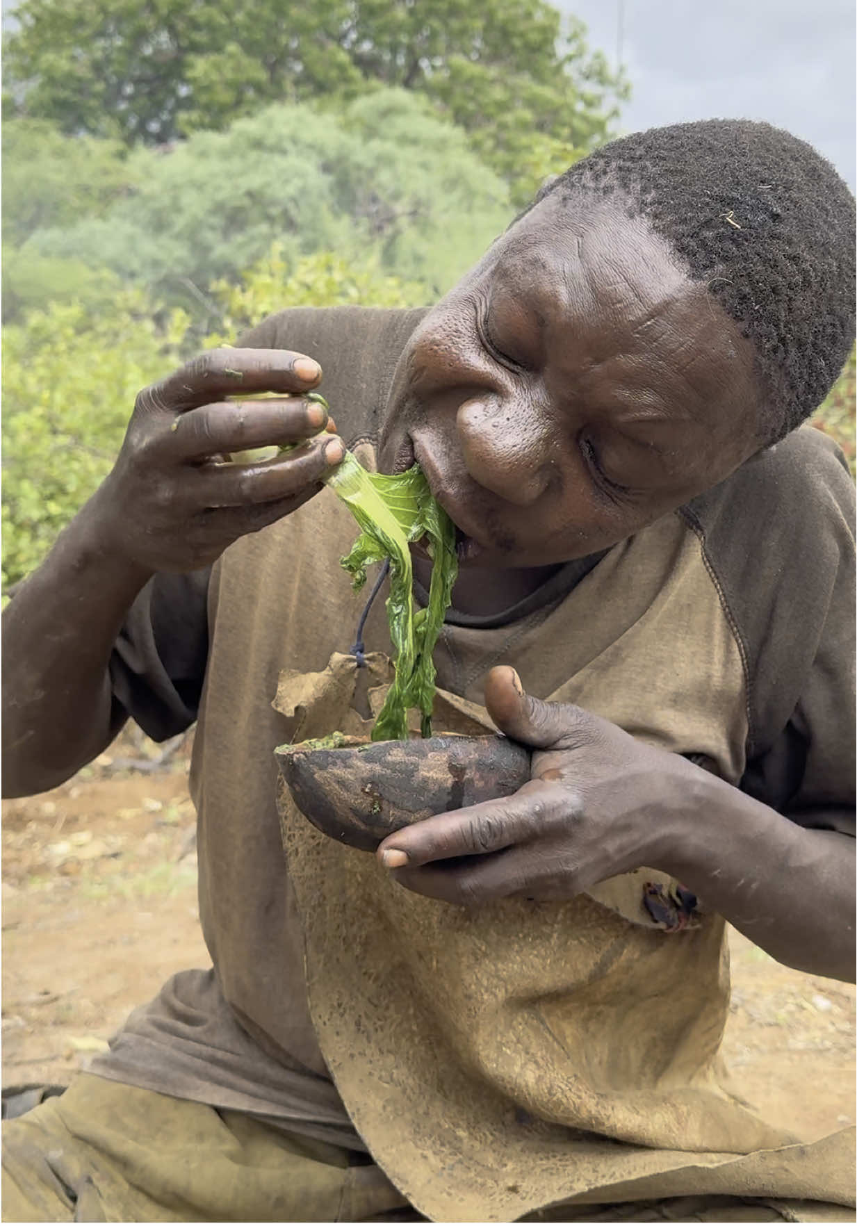 Chaba enjoying every sip of his veggie broth 🥣 🥬🥦🍅🥕 Chaba slurping that warm vegetable broth and savoring fresh spinach and tomatoes with pure delight 😋. Looks like this hunter doesn’t just stick to meat anymore — now he’s loving his greens too! 🌿 #travelling #tanzania #tribelife #africatribe #naturelovers #vegetables 