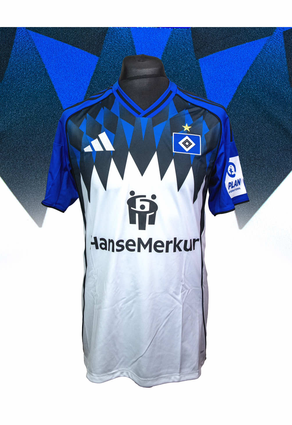 🔷 Hamburg SV 2025/26 Home by Adidas #Hamburg #jerseys #footballshirts #fußball #marksjerseys #HSV #fyp @hsv_official  🦕 Der Dinosaurier! Hamburg are one of Germany's oldest clubs and held the remarkable record of being the only side to never be relegated from the Bundesliga from its founding in 1963 to 2018. After 55 years they found themselves in the 2.Bundesliga for the first time and only just won promotion back to the big time. In celebration of their return Adidas have produced an absolutely magnificent home shirt. The design revives and reimagines one of HSV’s most iconic jerseys, the 1994–95 diamond motif. Instead of red and black diamonds, they refreshed the graphic with a bold blue-and-black sawtooth pattern sweeping across the shoulders and upper chest, flowing into the crisp white torso. The shoulders and sleeves are in a rich royal blue with a small black cuff while the three strips featured in black. The collar also sees a blue and black combo and looks really classy. The club crest is one of my absolute favourites and it is beautifully embroidered on this shirt as is the Adidas logo. The HanseMerkur logo sits on the centre of the chest, the back of the shirt is entirely white with the full club name running along the back of the shoulders. The sleeves feature the Bundesliga and Plan International patches while the side vents see a tapered black design. I have always loved the Hamburg club crest and this design finally gave me a reason to add a shirt to my collection. After seven long years Hamburg are back and they're bringing the style. Hopefully they'll be here to stay!  - - - #Hamburg #HamburgerSV #HSV #DerDinosaurier #DieRothosen #nurderHSV #Jerseys #ClassicJerseys #FootballShirts #ClassicFootballShirts #FootballShirts #FootballJerseys #MarksJerseys #FootballShirtCollection #SoccerShirts #Collection #JerseyCollection #FootballShirt #Fußballtrikot #Fußball #HamburgerSportVerein #Adidas #Trikot 