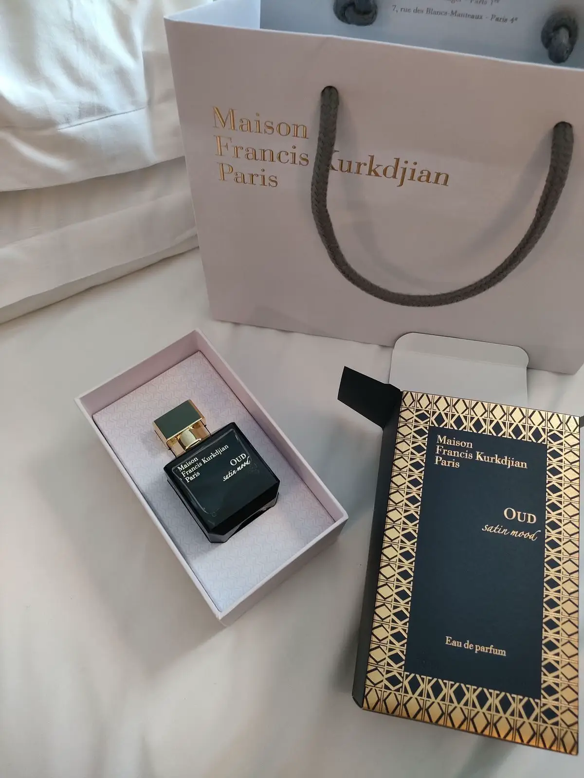 🌟Maison Francis Kurkdjian Paris Oud Satin Mood🌟 Maison Francis Kurkdjian’s Oud Satin Mood, released in 2015 and composed by Francis Kurkdjian, is not merely a fragrance — it is a fabric you can smell, a texture you can feel without touching. Not the fleeting transparency of chiffon, not the rough comfort of wool, but satin: weighty enough to drape, smooth enough to seduce, and luminous enough to catch light in the quietest corners. From the first spray, it slips over you like a tailored garment that changes the way you stand, the way you breathe, the way the room receives you. It begins with the unmistakable union of Bulgarian damask rose and Turkish damask rose absolute. The Bulgarian rose opens first, its brightness honeyed and golden, a living bloom kissed by sunlight. The Turkish rose follows closely, darker, deeper, with a jammy richness that feels decadent — like crimson velvet pressed between the pages of a leather-bound book. The two do not fight for attention; they move together in perfect tempo, shifting between radiance and shadow, like satin folds turning under candlelight. Then comes the violet, drifting in quietly, a delicate haze that smooths the roses’ edges until they lose their rawness and become silk to the senses. It is neither candied nor overly powdery — just a fine, gossamer veil, diffusing the florals into something impossibly polished. Beneath them, the warmth of Siam benzoin begins to rise, resinous and golden-brown, carrying a faint caramel glow that softens the space between the floral brightness and the shadows to come. And then, the oud. Laotian oud, rich and grounded, appears without a dramatic entrance. This is not the wild, animalic oud of fearsome reputation. It is refined, confident, and smooth, carrying the depth of dark wood polished by time and touch. It moves through the composition like a dark satin ribbon threading its way around the roses and benzoin, binding them in quiet luxury. It does not dominate — it shapes, sculpts, and deepens. As the scent moves further into its journey, vanilla begins to unfurl. Not the playful sweetness of desserts, but a molten, creamy smoothness that feels warm against skin, softening every sharper edge. Amber glows beneath it, a golden ember that radiates through the fabric of the scent, lending it both comfort and grandeur. The interplay between these notes creates the impression of silk in motion — light catching on folds, shadows pooling where the fabric bends. From the moment it touches skin, Oud Satin Mood carries a steady, confident projection. In the first hours, it announces itself with elegance, moving ahead of you by several paces, leaving a trail that is impossible to mistake. People will catch it in the air as you pass, and long after you leave, it lingers, a phantom presence in the room. As time passes, it draws closer to the skin, but never loses its pull; even at the tenth hour, it blooms again with each movement. On fabric, it is near immortal — clinging for days, holding the memory of the night it was worn. The sillage is not aggressive, but commanding in its subtlety — the kind of trail that makes people turn their heads without quite knowing why. This is not a scent for blending into the background. It is for evenings when you want to be remembered, for moments that deserve the full weight of presence. Wearing it feels like being draped in something both protective and revealing — satin that shields the body while amplifying the soul. It is a love story between rose and oud, but told with refinement, not drama; every note carefully placed, every movement intentional. #mfk #maisonfranciskurkdjian #oudsatimood #oudperfume #luxuryfragrance #oudandrose #nicheperfume #fragrancetok #perfumetiktok #perfumereview #scentsation #fragrancecollection #fragranceblogger #perfumejourney #luxurylifestyle #fragranceaddict #perfumeobsessed #perfume