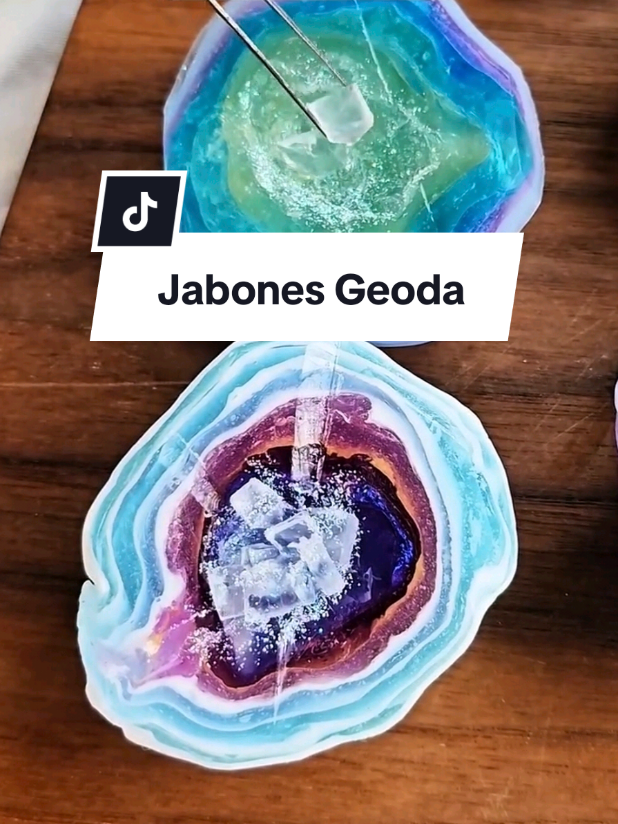 💎 El truco para que tus jabones parezcan piedras preciosas reales. 1. Fundí la base de glicerina transparente y dividila en varios recipientes. 2. Coloreá cada porción con micas y óxidos: tonos profundos para el centro, pasteles para las capas. 3. Tenés 3 formas: podés forrar un palito con una bola de aluminio como el video, también forrar con papel/aluminio una pequeña “cazoleta” para usar como molde interno, o por último, formá una taza con papel aluminio. 4. Verté o sumergí una capa base fina en el molde principal y dejá que forme piel. 5. Colocá la cazoleta de aluminio centrada sobre esa capa para crear la cavidad de la gema. 6. Hacé capas alternando colores, dejando que se forme la piel entre cada vertido para que no se mezclen. 7. Para el corazón “geoda”: triturá glicerina transparente sólida en trozos (o usá fragmentos de jabón claro) y rellená la cazoleta. 8. Verté glicerina transparente tibia para asentar los cristales y sellar el centro. 9. Retirá con cuidado la cazoleta/almidón de aluminio una vez que esté firme y rellená el hueco si hace falta. 10. Rematá con mica en polvo y un toque de glitter biodegradable para brillo real. 11. Tip pro: rociá con alcohol isopropílico entre capas para evitar burbujas y mejorar el pegado. 🌀 Cursos de velas, jabones y cosmética natural → Link de mi perfil ✨️ #jabonesartesanales #jabonartesanal #cosmeticanatural #hechoamano #jabonvegano #emprenderencasa #cursosonline #gemasnaturales #jabondeglicerina #ExitoEnUnPote 