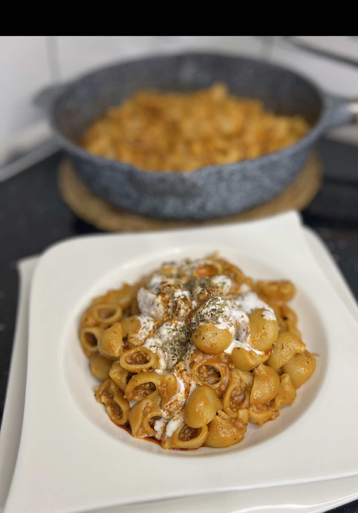 🍝 Pasta Turke me Mish të Grirë 🍝 Përbërësit: 	•	300g mish viçi i grirë 	•	500g makarona 	•	1 qepë 	•	2 thelpinj hudhër 	•	300ml salce domate  	•	1 lugë gjelle pure domatesh 	•	900 ml ujë i nxehtë 	•	1,5 lugë mesme rigon 	•	1,5 lugë çaji spec i kuq i grimcuar  	•	Kripë Për salcën me kos: 	•	Kos 	•	1 thelb hudhër 	•	Pak kripë Për gjalpin sipër: 	•	1 lugë gjelle gjalpë 	•	Spec i kuq pluhur 	•	Spec i kuq i grimcuar   ⸻ Përgatitja: 	1.	Qepa dhe hudhra skuqen lehtë në pak vaj. 	2.	Shtohet mishi i grirë dhe vazhdohet kavardisja. 	3.	Shtohet salca e domates dhe kavërdiset pak. 	4.	Shtohet pureja e domates, përzihet disa herë me lugë, pastaj shtohen makaronat, kripa dhe erëzat. 	5.	Pasi kavërdisen pak, shtohet uji i nxehtë. 	6.	Gatuhet në zjarr mesatar, me kapak të mbyllur, duke kontrolluar dhe përzier herë pas here derisa makaronat të ziejnë dhe të përthithin lëngun. Shërbehet me salcën e kosit me hudhër dhe me gjalpin e shkrirë me erëza sipër !  Ju bëftë mirë nese e pregadisni !! #kuzhinaearbreshes #turkishpasta #pasta #pastaturke #Recipe 