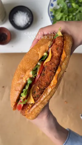 Crispy chicken sandwich  Ingredients  For the chicken  1 chicken breast, halved lengthwise and pounded  Salt to taste 1 tsp black pepper  1 tbsp garlic powder  1 tsp smoked paprika powder  1 tsp onion powder  For the egg batter: 1 egg  1/3 cup water For the dry batter: 1 cup all purpose flour  Salt to taste 1 tsp black pepper  1 tbsp garlic powder  1 tsp onion powder  1 tsp smoked paprika powder  For the breadcrumbs: 2 cup panko bread crumbs  1 tbsp dried parsley  For the sauce : 1/2 cup mayonnaise  1 tsp Dijon mustard  2 tbsp hot sauce ( less or more adjust to taste) 1/2 tsp black pepper  1 tbsp garlic powder  1 tsp smoked paprika powder  Salt to taste  To assemble: 4 mini loafs of bread  4 tbsp butter ( for toasting the bread ) 4 slices American cheese  2 tomatoes, thinly sliced  1/2 cup pickles  1 cup lettuce diced Method: In a bowl add salt , pepper, smoked paprika powder, garlic powder, onion powder. Mix well. Pat dry the chicken, sprinkle the spice blend on both sides of the chicken. In a bowl combine all purpose flour, salt , pepper, garlic powder, onion powder and smoked paprika powder. Mix well  In a separate bowl crack an egg add water, whisk until well combined. In another bowl add panko bread crumbs and dried parsley . Mix well. Coat the seasoned chicken in dry batter then in egg batter , repeat again with dry and wet batter. Lastly coat the chicken with bread crumbs. Heat oil in a pan until it reaches 350 F, fry  the chicken for 3-5 minutes flipping sides in between or until the internal temperature of the chicken reaches 165 F Make the sauce by mixing mayonnaise, hot sauce, Dijon mustard salt, pepper, paprika, garlic powder in a bowl. Apply butter on bread and toast until golden. Spread the sauce on top. Add crispy chicken fillet on top. Top it with cheese slices.Add tomatoes, pickles, lettuce on top. Add more sauce on the top bun and close. Serve warm and enjoy. #crispychicken #sandwich #Recipe 