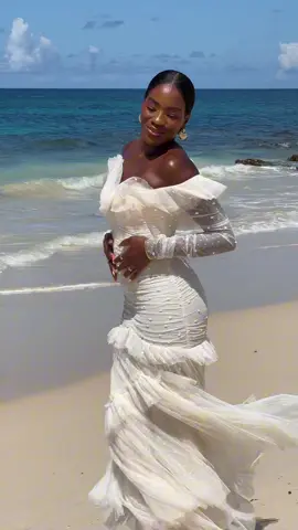 Look to @Armelle Brown who brings refined elegance to the shores of Martinique in our Sequin Glimmer 🩷 Recognised for its couture-inspired look, this special design exudes grace with a frilled off-shoulder neckline and romantic flourishes. 