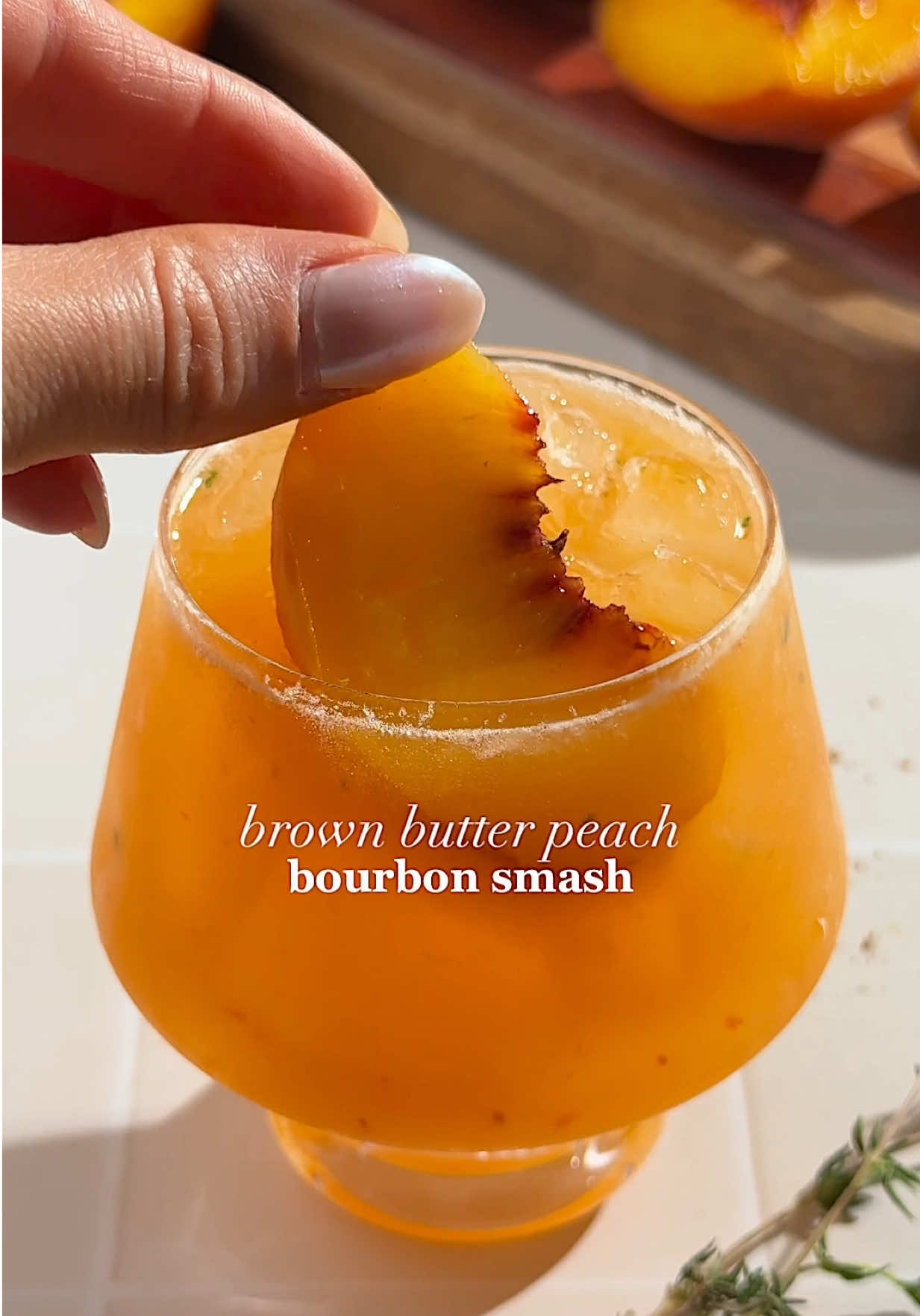 Peach season isn’t over yet 🗣️ try this Brown Butter Peach Bourbon Smash! 🍑🥃 2 oz brown butter bourbon*  3 slices peach, ripe 2-3 sprigs thyme .75 oz maple syrup or brown sugar syrup  .75 oz lemon juice, fresh Method: combine thyme, peaches, and bourbon in a cocktail shaker and muddle. Add in the rest of the ingredients with ice and shake. Strain into a glass over ice (fine strain if you’d prefer no bits in your cocktail- I actually enjoy the little peach bits in this one though!). Garnish with a peach slice, cinnamon, and thyme. *brown butter bourbon: brown 1 stick of butter and let cool. Combine in a jar with 20 oz bourbon and stir or shake. Place lid on jar and let sit at room temp for 2 hrs, shaking every 20 mins or so. Place in freezer overnight. The next day, remove fat from top using a fine mesh strainer and strain with a coffee filter. Store remaining bourbon in fridge and use within 1 week.  Cheers! #Cocktail #cocktails #cocktailrecipe #cocktailrecipes #fyp 
