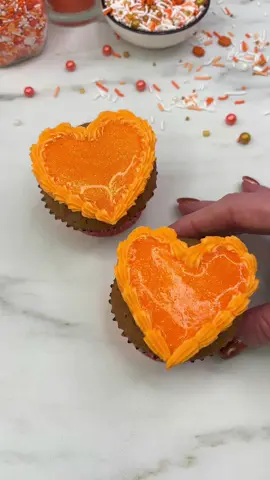 🧡 Showgirl cupcakes 🧡 They are in their showbiz era 🧡🧡🧡 🧡 Use a large round piping tip to pipe a heart. 🧡 Smooth it out with a palette knife. 🧡 Add a shell border using a small star tip. 🧡 Chill them. 🧡 Add edible glitter to orange Jelly. When it’s really cold, add it to the cupcakes and then let them set in the fridge.  ❤️‍🔥 And, baby, that’s show business for you! #cakedbyrach #cupcake #cakedecorating #cakeart #ts12    