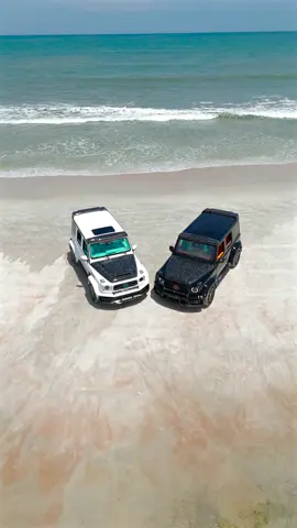 Two Mansory G63s, one with a Tiffany Blue interior, the other with a deep orange, bringing super-SUV presence to the sand🔥 