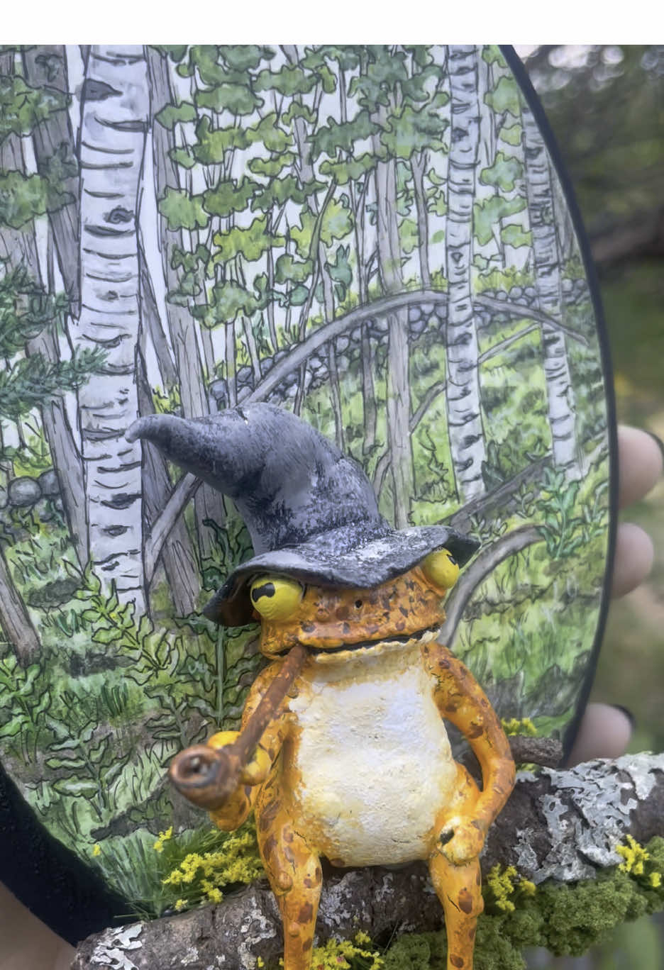 Collaboration piece with my amazing and talented partner @TheMossyPossum 💖 we’ve been wanting to make something together for a while, and I’m so grateful we were finally able to! Background done by me using a wood plaque coated in absorbant ground (this magical stuff that makes it so you can use water mediums on any surface) with watercolors and ink fineliner pens. Toad sculpted by my partner using 2 part epoxy clay, acrylic paints, some sticks, moss, and some other random findings. I couldn’t be happier with how it turned out, and I hope you guys like it too! #watercolorpainting #sculpting #toad #cutecouples #artistsoftiktok 