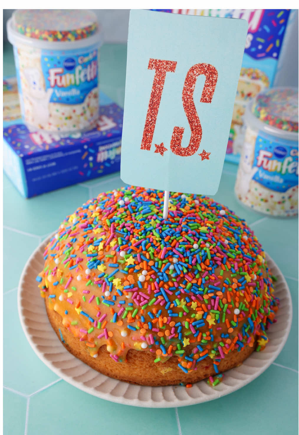 In our showgirl era 🧡💚 @Taylor Swift @Taylor Nation  Want to shake it off like Tay Tay and make a sprinkle tsunami cake at home?💃 You’ll need...⁠ 1 box Funfetti Celebrations Cake Mix with Candy Bits & Premium Decorating Sprinkles⁠ ⁠Additional ingredients to prepare cake mix per box instructions⁠ 1 tub of Funfetti Confetti Vanilla Frosting⁠ Orange food coloring Cake topper  Large round cookie cutter or biscuit cutter⁠ ⁠ Directions:⁠ 1. Prepare cake mix according to box directions in a domed cake pan or oven-safe bowl. Or, cut the dome off a cake layer. Let cool completely.⁠ ⁠ 2. Remove all foil from frosting tub. Right before serving, microwave frosting for 30-45 seconds or until frosting is pourable.⁠ Tint as desired with orange food coloring.  ⁠ 3. Place cake on serving plate. Place your large round cookie cutter in the center, gently pressing just slightly into the cake. Fill with melted frosting, and top with sprinkles included with box mix.⁠ ⁠ 4. Add cake topper in center. When serving, lift slowly to let the sprinkle tsunami flood gates open! #funfetti #fyp 