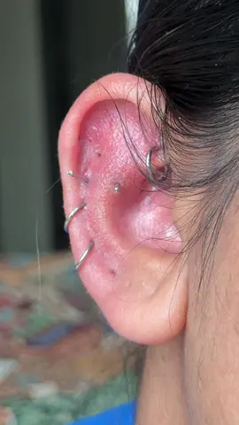 love a good before and after hehe :):) #piercing #earstack #earrings #jewelry #fyp  the piercings in this ear are a rook piercing, outer conch or contra conch, two helix piercings, an almost flat piercing, and two industrials: one traditional industrial and one vertical industrial. there are also three lobe piercings. 