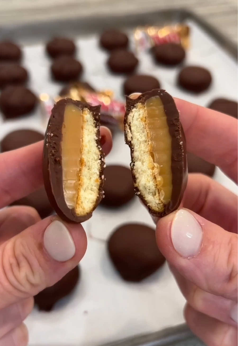 Homemade Twix Bites 🍫🍬 Gooey caramel on top of crispy vanilla wafer cookies all covered up in a scrumptious chocolate coating. You won’t be able to put them down! ⬇️ INGREDIENTS: 24 caramel squares 24 round vanilla wafer cookies 2 cups semi-sweet chocolate chips INSTRUCTIONS: 1. Preheat oven to 250°F. Unwrap and place the caramels a few inches apart on a parchment-lined baking sheet. Place the baking sheet on the middle rack of the preheated oven for 5 minutes to soften the caramels. They should not melt. They should just soften so that you can reshape them. 2. Meanwhile, arrange the vanilla wafer cookies, bottom sides up, on a small parchment-lined sheet pan that will fit in your freezer. 3. Remove the caramels from the oven, and while they’re still warm, slightly flatten each caramel into a circle shape that will fit the size of the wafer cookies. Place each flattened caramel on top of each cookie on the sheet pan. 4. Place the sheet pan of bites in the freezer for 15 minutes. 5. When you’re ready to coat the bites in chocolate, place 1 cup of the chocolate chips in a microwave-safe bowl and microwave in 30 seconds intervals until melted and smooth, stirring between each interval. 6. Remove half of the flash frozen bites from the freezer. Using a fork, dip and coat each bite completely in the melted chocolate, letting any excess chocolate drip back into the bowl before transferring the coated bite to a parchment-lined sheet pan. 7. Repeat with the remaining 1 cup of chocolate chips and remaining bites that are in the freezer. 8. Let the bites set at room temperature until the chocolate is completely set. Store in an airtight container at room temperature for up to 2 weeks.