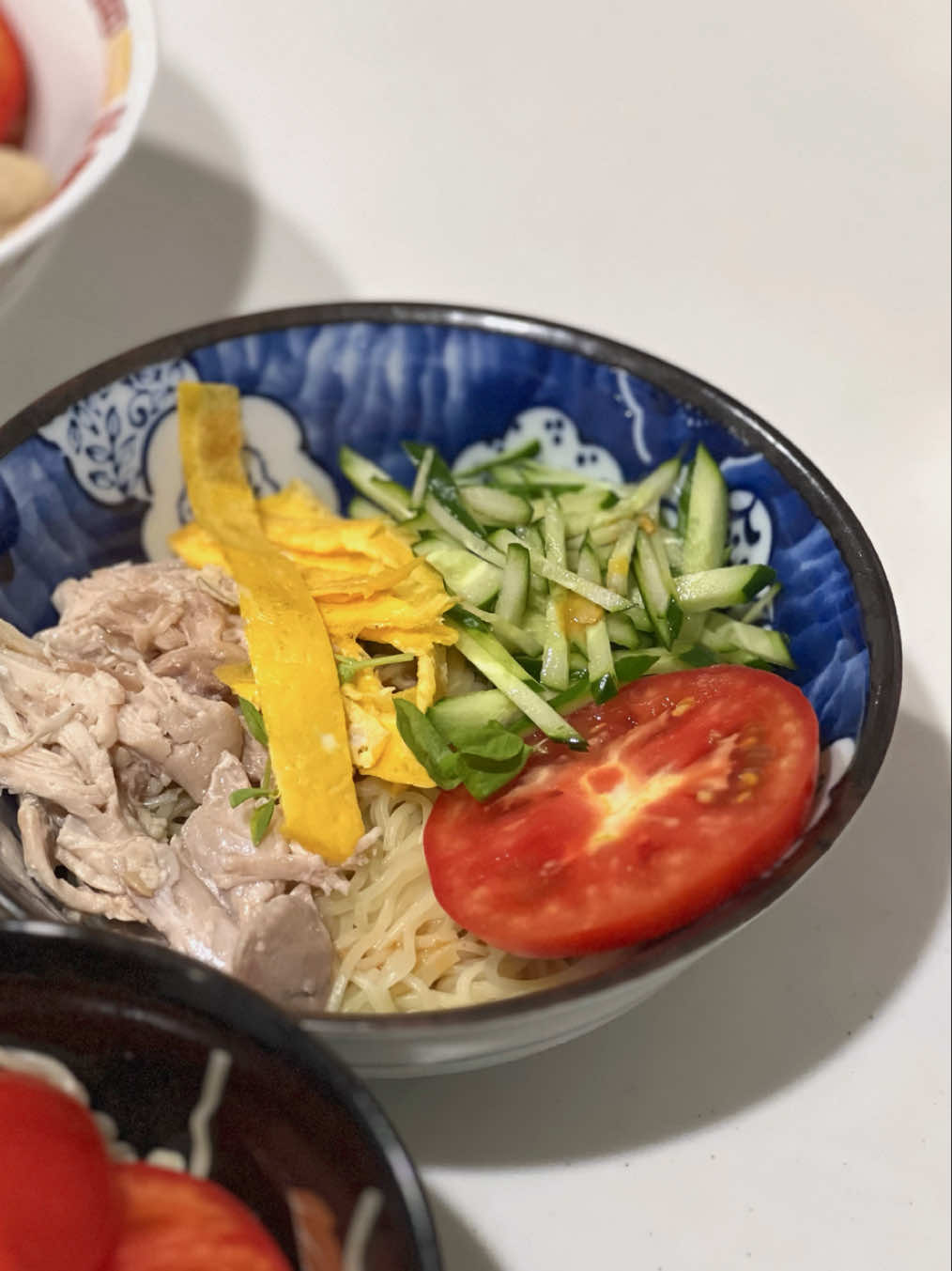 My family always gets excited whenever I make this — especially my daughter! I still remember the first time I tried making it; it felt like it took so much effort. But like most dishes I cook, the more I made it, the easier it became. Living in Japan is the first time I’ve eaten something cold in summer that isn’t sweet or a dessert — and now it’s one of our favorites.  Macros per 1 serving: Calories: 284 kcal Protein: 24 grams  4 Servings  Ingredients: Maruchan Hiyashi Naman Ramen (冷し生ラーメン) - 2 packs (comes with the soy sesame sauce) 2 cucumbers 1 big tomato 2 boiled chicken thighs 2 eggs - thin omelette   Instructions: - Wash and slice the cucumbers and tomato. - Boil the chicken thighs, then shred them. (Using two forks works better than the hand-mixer hack, unless you’re using chicken breast, which shreds more easily.) - Cook the noodles according to the package instructions. Once done, place them in an ice bath or rinse under cold running water. Drain well, transfer to a bowl, and mix in the sauce. - Whisk the eggs. In a non-stick pan, lightly grease with a thin layer of oil (spread it evenly with a paper towel). Pour in the eggs and spread evenly. Cook on low heat until set, then let it cool slightly. - Once cooled, fold the omelet in half, then in half again. Stack if needed, and slice thinly into strips. - Assemble the cold noodles: top with cucumber, tomato, shredded chicken, and omelet strips. Enjoy!