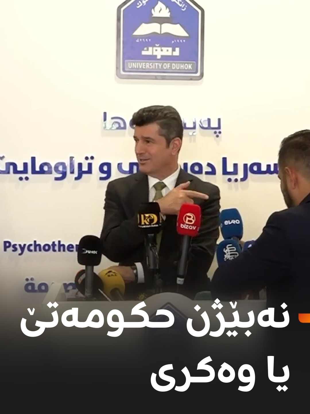 د رێوره‌سمێ ڤه‌كرنا كلینیكا ئای پی پی بۆ چاره‌سه‌ریا ده‌روونی یا ئالۆده‌بوونێ ل زانكۆیا دهۆك، بەری کو پارێزگارێ دهۆکێ گۆتارا خوه‌ پێشکێش بکەت، په‌یامنێره‌ك مایكێن به‌ر سینگێ وی دئێخیت. پارێزگار ژی مایكا رووداو رادكه‌ته‌ڤه‌ و دبێژیت 