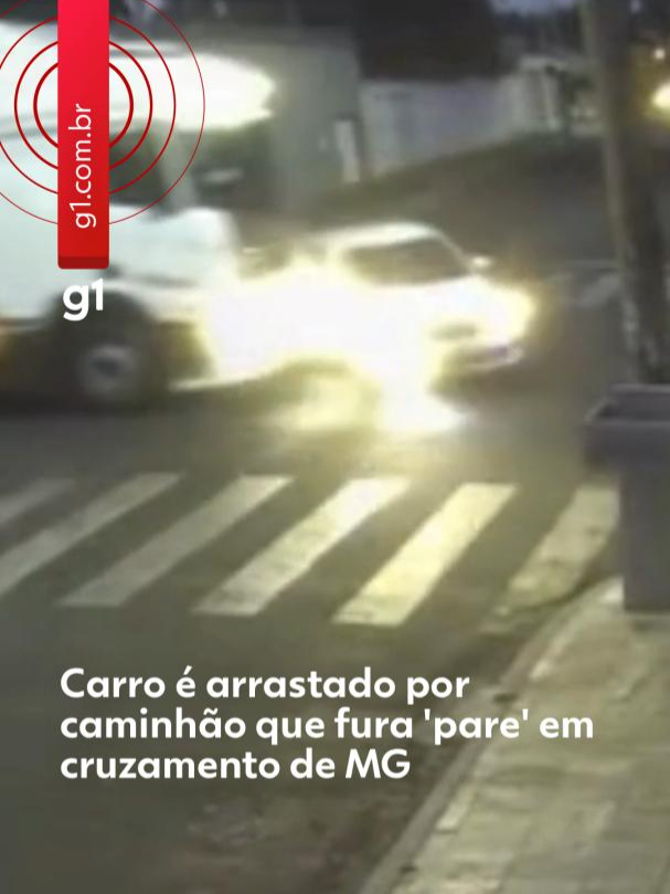 Motorista fugiu - Um idoso de 72 anos e um adolescente de 14 ficaram feridos após o carro em que estavam ser atingido e arrastado por um caminhão que não respeitou a sinalização de “pare” em um cruzamento de Ituiutaba, no Triângulo Mineiro.  O acidente aconteceu na manhã desta quinta-feira (21) e foi registrado por uma câmera de segurança. As imagens mostram o carro trafegando pela Rua Fausto Próspero quando o motorista do cavalo mecânico, que seguia pela Rua Cláudio Manoel da Costa, passa direto no cruzamento e atinge em cheio a lateral do veículo de passeio. Em outro ângulo, é possível ver que o carro foi arrastado por alguns metros até conseguir se esquivar e parar na entrada de um estacionamento. Também é possível ouvir a frenagem do caminhão após a batida.  O acidente aconteceu em frente à Escola Estadual Professora Maria de Barros, que estava fechada no momento. De acordo com o Corpo de Bombeiros, as duas vítimas tiveram apenas ferimentos leves e receberam atendimento médico. O motorista do caminhão fugiu após o acidente. Para saber mais, clique em 'leia o artigo' #g1 #tiktoknotícias #caminhão #cruzamento #ituiutaba #minasgerais