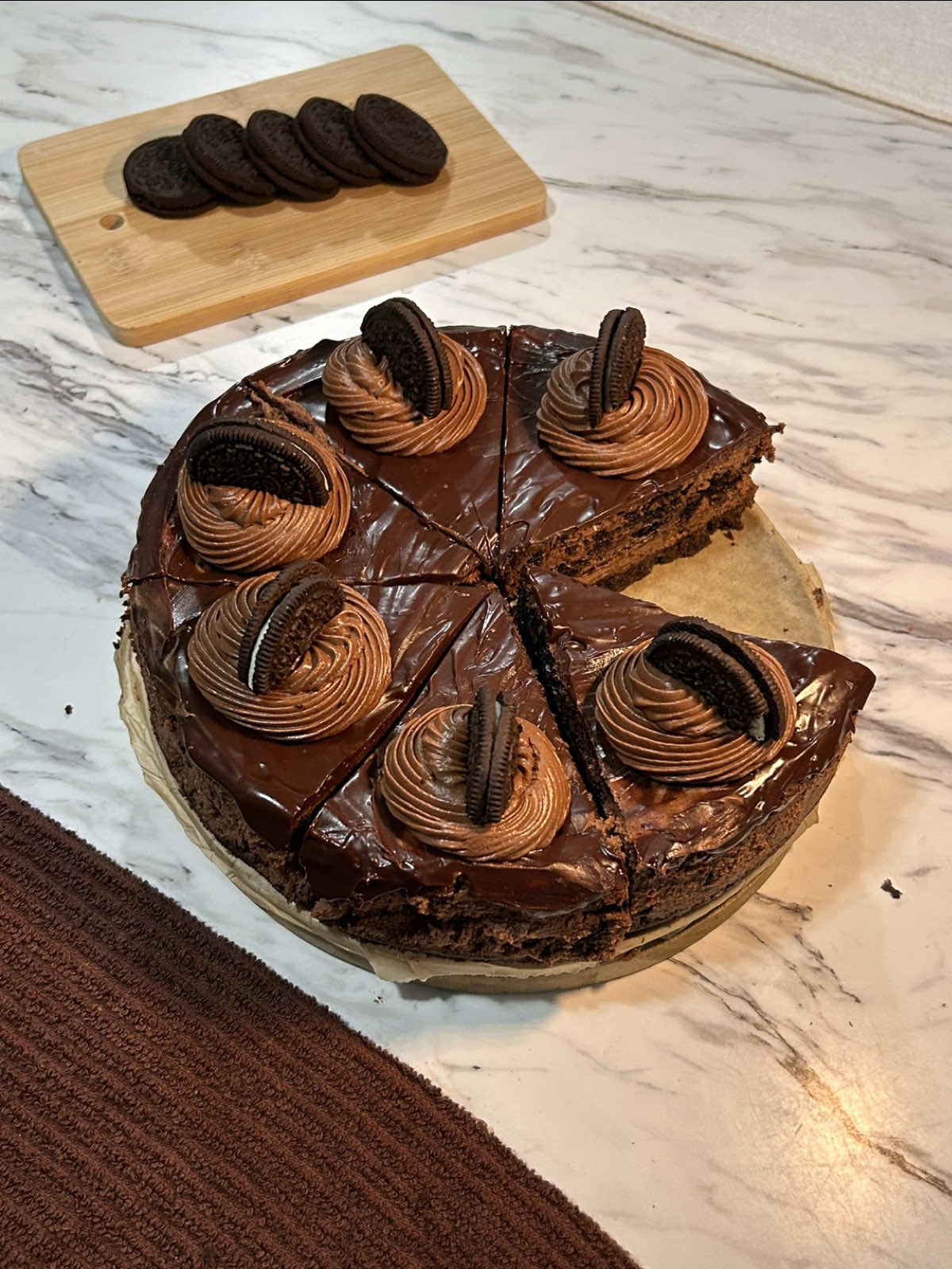 creamy chocolate oreo cheesecake 🤎 bye this came out SO good.    easy recipe:   crust: •3 packs chocolate graham crackers( i used @Honey Maid ) or use about 24 oreos.  •¼ cup + 2 tbsp (90 g) unsalted butter, melted finely crush the graham crackers & add the melted butter, ( you may need more butter depending on your preference. ) press into a lined 8x8 spring form pan & set aside.    cheesecake:  • 3 blocks (24 oz / 675 g) cream cheese, room temp • 1 cup (200 g) granulated sugar • ½ cup (120 g) sour cream, room temp( or plain greek yogurt ) • 3 large eggs, room temp • 8 oz (225 g) dark or semisweet chocolate, melted & slightly cooled • 2 tbsp (15 g) unsweetened cocoa powder • 1 tsp vanilla extract • pinch of salt • 5 oreos, roughly chopped (for folding in)    preheat your oven to 325•F. for the filling, beat cream cheese and sugar until smooth, then mix in sour cream, cocoa powder & vanilla . add eggs one at a time mixing gently, then fold in your cool melted chocolate , and fold in chopped oreos. pour the filling over the crust ( if you’re doing a water bath wrap the aluminum foil tightly around the cheesecake and place in the water) bake for 55-65 minutes, until the edges are set and the center is still slightly wobbly, like jello. turn off the oven, leave the door cracked, and let the cheesecake rest for an hour before bringing it to room temperature. once you take the cheesecake out of the oven run a knife across the edges to prevent it cracking when cooling.  after it comes to room temp, chill overnight. ( ideally at least 4 hours, but i recommend 7+) ganache topping : • ½ cup (120 ml) heavy cream • 4 oz (115 g) dark or semisweet chocolate( 2/3 cup ) 3-4 oreos, ( for the top)   for the topping, make a ganache by heating heavy cream and pouring it over chocolate chips, stirring until glossy. spread a thin layer over the cheesecake and i whipped some of the cooled ganache to pipe around the edges and finished with oreo halves on top.   ( baking tip: i HATE doing the water baths for the cheesecake so instead i put a pan on the rack underneath the cheesecake and fill it with boiling water. )   some extra tips: make sure the cream cheese, eggs & sour cream are room temp. this helps prevent lumps.    don’t overmix when adding the eggs, it can incorporate too much air into the cheesecake  enjoy!! :)    #oreo #chocolate #cheesecake #Recipe #baking 