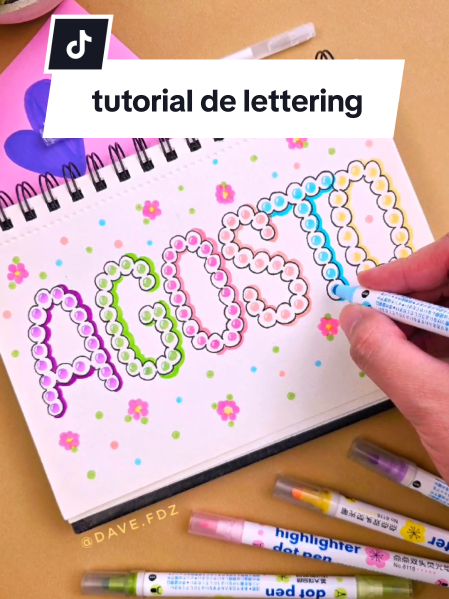 Cómo hacer esta letra con marcadores? #lettering #ideasen5minutos #letrasbonitas #tarjetas #portadasbonitas  Tutorial de lettering! 🌺😍 Hoy les comparto mi nueva portada de mes en el cuaderno, hecha con unos marcadores que compré en uno de mis viajes y que son ¡pura diversión! 💖 Cada letra parece estar formada por pequeñas cuentas o perlitas en tonos pastel 🎨. La técnica es súper relajante, ideal para desconectar un rato y dejarse llevar. Para darle más vida, sumé bordes con microfibras, sombras con punta pincel y algunos detalles decorativos como flores y hojitas 🌸🍃. Si no tienen estos marcadores  los pueden hacer con marcadores que tengan punta redonda.✨😍 El resultado es un estilo original, colorido y lleno de buena vibra. Perfecto para portadas de cuadernos, escribir tu nombre, decorar apuntes o simplemente practicar lettering de manera distinta ✍️💡 ¿Les gusta?  👉 ¿Se animan a hacer el resto del abecedario con este estilo de lettering? Déjenme en comentarios si quieren más videos con esta letra, y si lo prueban, ¡etiquétenme para ver sus creaciones!❤️  