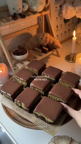 Pt.4 | My fall bakery menu 🍂 Recipe below 👇🏼  Crumbl released their Dubai Chocolate Brownie, but why buy it when you can make an even better one at home? 🤎✨ Ingredients 🟤Brownie Base * 180g caster sugar * 2 eggs * 113g unsalted butter (for browning) * 170g chopped chocolate * 80g plain flour * 3 tbsp cocoa powder * ½ tsp salt 💚Kunafa Filling * 260g kunafa pastry (finely chopped) * 2 tbsp unsalted butter (for toasting kunafa) * 320g pistachio cream 🍫Chocolate Ganache * 120g double cream * 100g milk chocolate (chopped) Instructions 1. Preheat the oven to 170°C and line a baking pan with parchment paper. 2. Brown 113g of unsalted butter in a saucepan until golden, then set aside. 3. Melt the chopped chocolate in the microwave in short bursts until smooth, then stir in the browned butter and let cool slightly. 4. In a separate bowl, whisk the sugar and eggs until light and fluffy. 5. Add the chocolate butter mixture to the eggs and sugar, and whisk until fully combined. 6. Fold in the flour, cocoa powder, and salt until just incorporated. 7. Pour all of the brownie batter into the prepared pan, smooth the top, and bake for 22 minutes. Let cool completely in the pan. 8. In a pan over medium heat, melt 2 tbsp of butter. Add the finely chopped kunafa pastry and cook, stirring often, until golden and crisp. Let cool slightly. 9. Mix the toasted kunafa pastry with the pistachio cream until fully combined, then spread evenly over the cooled brownie. 10. Place the pan in the fridge for about 30 minutes to set. 11. For the ganache, place the double cream and chopped milk chocolate in a microwave-safe bowl. Heat in short bursts, stirring in between, until melted and glossy. 12. Pour the ganache over the pistachio-kunafa layer, spread evenly, and refrigerate, ideally overnight, or at least 1 hour before slicing. Enjoy! 🤎 #baking #dubaichocolate #brownies #Recipe #fall 