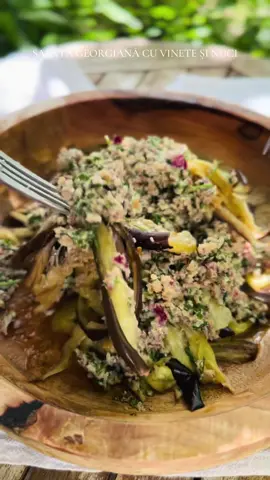 Salată georgiană cu vinete și nuci O salată autentică din bucătăria georgiană, plină de arome intense și texturi bogate. Vinetele coapte, moi și ușor afumate, se împletesc perfect cu sosul cremos din nuci, ierburi aromatice și condimente tradiționale. Este o rețetă simplă, dar cu gust profund, ce aduce pe masă un strop de rafinament oriental. Ingrediente: 	•	3 vinete 	•	4 linguri de ulei de măsline 	•	3 căței de usturoi 	•	1 ceapă 	•	½ linguriță coriandru uscat 	•	1 linguriță khmeli-suneli 	•	2 linguri oțet de mere 	•	3–4 linguri apă 	•	50 g nuci grecești 	•	½ legătură coriandru proaspăt sau pătrunjel 	•	sare și piper măcinat după gust Taie vinetele felii, presară-le cu sare și lasă-le 30 de minute să își lase zeama amară. Șterge-le cu un prosop de hârtie, unge-le cu ulei pe ambele părți și așază-le pe o tavă de copt. Coace vinetele în cuptorul preîncălzit la 200°C timp de 20 de minute. După coacere, acoperă-le cu un prosop și lasă-le să se înmoaie și să se răcească. Rupe feliile în fâșii și pune-le într-un bol. Într-un tocător, adaugă: nucile, coriandrul sau pătrunjelul, ceapa, usturoiul, condimentele (khmeli-suneli, coriandru uscat, sare și piper), oțetul de mere și apa. Mărunțește până obții o pastă aromată și cremoasă. Toarnă sosul peste vinete și amestecă delicat. Lasă salata câteva minute să se întrepătrundă aromele. O salată ușor acrișoară, aromată și hrănitoare, perfectă ca aperitiv sau garnitură. Poți să o servești simplă, cu lipie sau pâine de casă, iar gustul ei te va purta direct în inima bucătăriei georgiene. Georgian Eggplant and Walnut Salad An authentic salad from Georgian cuisine, full of intense flavors and rich textures. The ripe, soft and slightly smoked eggplants blend perfectly with the creamy sauce of walnuts, aromatic herbs and traditional spices. It is a simple recipe, but with a deep taste, which brings a touch of oriental refinement to the table. Ingredients: • 3 eggplants • 4 tablespoons of olive oil • 3 cloves of garlic • 1 onion • ½ teaspoon of dried coriander • 1 teaspoon of khmeli-suneli • 2 tablespoons of apple cider vinegar • 3–4 tablespoons of water • 50 g of walnuts • ½ bunch of fresh coriander or parsley • salt and ground pepper to taste Cut the eggplants into slices, sprinkle them with salt and leave them for 30 minutes to release their bitter juice. Pat them dry with a paper towel, brush both sides with oil and place on a baking sheet. Bake the eggplants in a preheated oven at 200°C for 20 minutes. After baking, cover them with a towel and let them soften and cool. Tear the slices into strips and place them in a bowl. In a food processor, add: walnuts, coriander or parsley, onion, garlic, spices (khmeli-suneli, dried coriander, salt and pepper), apple cider vinegar and water. Chop until you get a fragrant and creamy paste. Pour the sauce over the eggplants and mix gently. Let the salad sit for a few minutes for the flavors to blend. A slightly sour, aromatic and nutritious salad, perfect as an appetizer or side dish. You can serve it plain, with pita bread or homemade bread, and its taste will take you straight to the heart of Georgian cuisine.