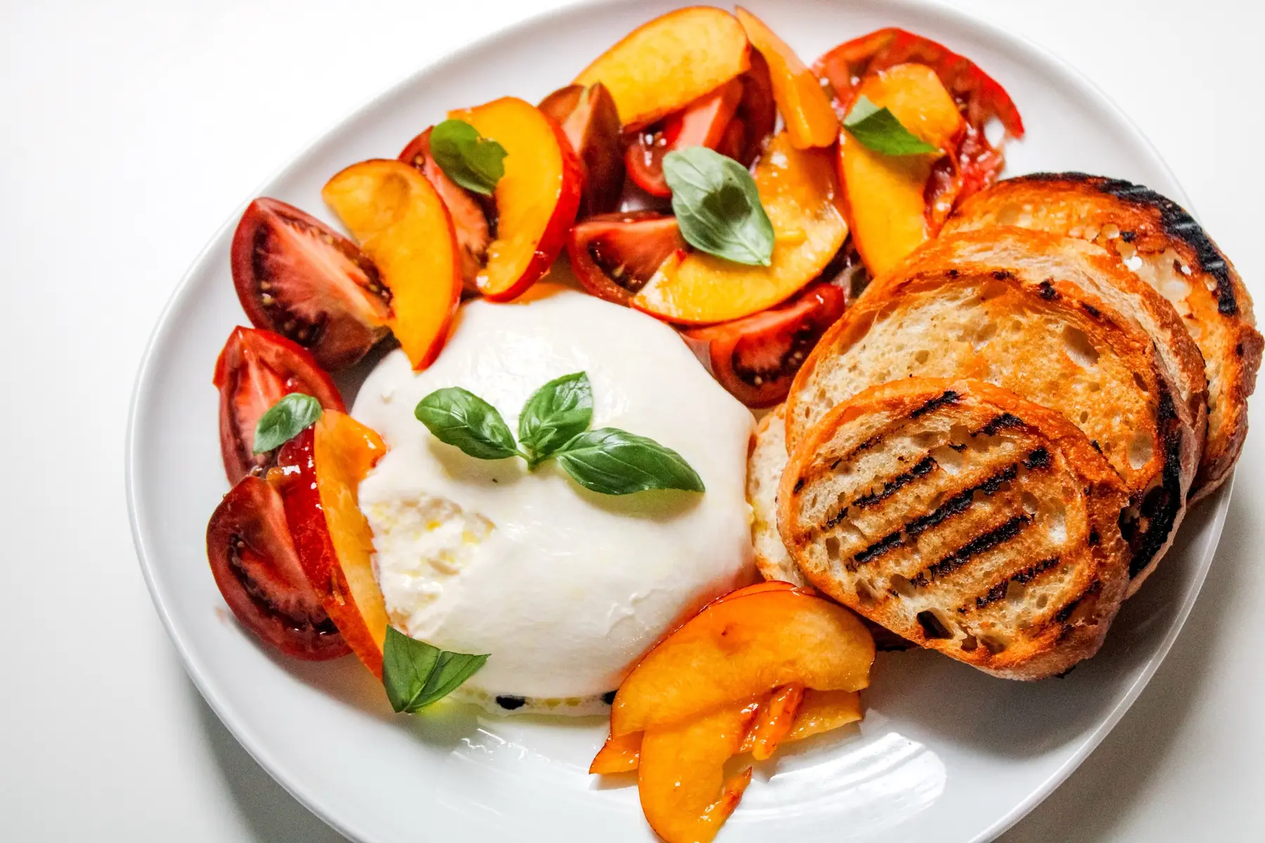 One of my favorite parts about summer is how simple ingredients can come together to make something unforgettable. I picked up a jar of local peach jam, and instead of saving it just for toast, I tossed it with fresh peaches and tomatoes from the market. A sprinkle of salt and pepper, a little creamy burrata, and some grilled sourdough on the side. Sweet, savory, creamy, and crunchy all in one bite #peach #homechef #summersnack 