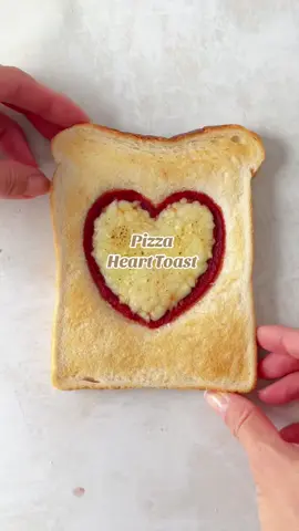 My original viral heart toast, and still one of my faves. Just press a heart shape into a slice of bread using a spoon, fill with tomato sauce and grated cheese, then bake until golden and melted. Watch until the end for the cheese pull! #pizzatoast #hearttoast #heartpizzatoast #funtoastideas 