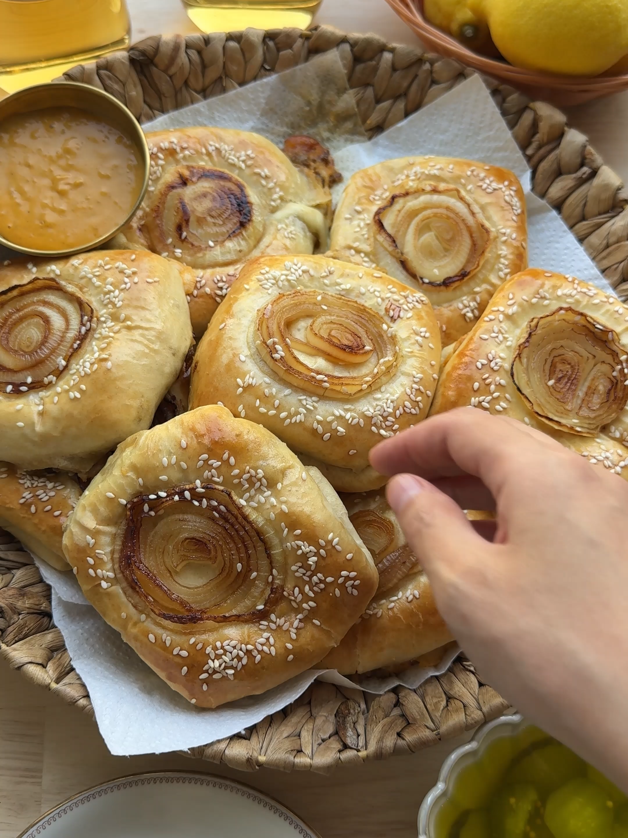 CHEESE ONION BREAD WITH BEEF #food #recipe #beef #cheese #onion #bread #tasty #fy #fyp #foryoupage DOUGH 150 ml milk (lukewarm) 75 ml water (lukewarm) 7 g yeast (1 tablespoon or 1 packet) 15 g honey 400 g flour (plain/patent flour) 7 g salt (1 ⅙ teaspoons) 25 g unsalted butter BEEF MIXTURE  25 ml olive oil  125 g yellow onion (1 onion) 425 g ground beef 2 g paprika powder (⅔ teaspoon) 2 g cayenne powder (⅔ teaspoon) 2 g black pepper (⅔ teaspoon) 4 g onion powder (1 ⅓ teaspoons) 2 g garlic powder (⅔ teaspoon) 125 g Gouda cheese 12 ml soy sauce 25 g ketjap manis ONION MIXTURE 25 ml sunflower oil 125 g yellow onion (1 onion) 10 g ketjap manis SERVE WITH gouda cheese cheddar cheese sauce of choice pickles EXTRA 1 egg (medium) sesame seeds Instructions In a deep bowl, combine lukewarm milk, lukewarm water, yeast, and honey. Mix well and let rest for 5 minutes. Add flour, salt, and butter. Knead the dough for 10–12 minutes until smooth. Cover and let it rise in a warm spot for 1 hour, or until doubled in size. Heat olive oil in a frying pan over medium heat. Add the chopped onion and sauté for 2–3 minutes. Add ground beef, paprika, cayenne powder, black pepper, onion powder, and garlic powder. Cook for 8 minutes. Add grated Gouda cheese, soy sauce, and ketjap manis, and briefly cook until everything is combined. Peel and slice the onion. Heat sunflower oil in a frying pan and fry the onion until golden brown on both sides. Add ketjap manis and cook briefly. Set aside. Deflate the dough and divide it into 9 equal pieces (about 75 g each). Shape into balls. Roll out a ball into a thin, square sheet. Place a slice of Gouda cheese in the center, spread some sauce of choice, and add 30 g of the ground beef mixture. Top with a slice of cheddar and some slices of pickle. Finish with another 30 g of ground beef. Fold the top edge of the dough over the filling, then fold the bottom edge over to overlap the top flap.  Fold the sides inward to form a tight square package. Place the buns seam-side down on a baking sheet lined with parchment paper. Brush with beaten egg, sprinkle the fried onions on top, and coat the edges with sesame seeds. Let them rise for 30 minutes. Bake in a preheated oven at 200 °C (390 °F, top and bottom heat) for 20–25 minutes until golden brown. Keep an eye on the oven, as each oven is different.