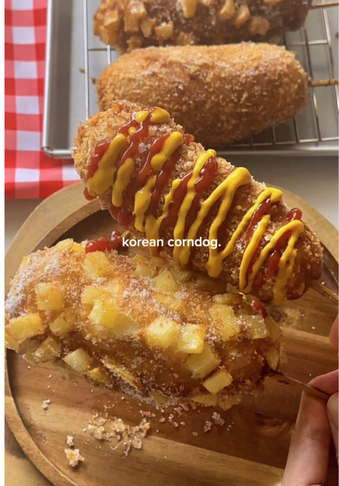 korean corndogs🌭🧀 Ingredients: 225g bread flour 75g all purpose flour 1 1/2 tsp salt 45g granulated sugar 6g instant yeast 1 large egg 160ml warm water  3 sausages Mozzarella cheese Panko bread crumbs 2 small potatoes + 2 tbsp cornstarch Instructions: Make the Dough: 1. In a bowl, whisk together the egg, sugar, and yeast 2. Add flour, salt, and water, then mix until a sticky dough forms. 3. Cover and let the dough rise for about 1 hour, or until doubled in size. Prepare the Potatoes: 1. Dice potatoes into small cubes. 2. Boil for 3–4 minutes, then drain and let cool. 3. Coat the cubes lightly with cornstarch and spread on a tray. Prepare the Fillings: 1. Cut sausages in half. 2. Slice cheese into pieces the same length as the sausage halves. 3. Skewer sausage and cheese together on sticks. Assemble the Corn Dogs: 1. Wrap the risen dough around each skewer until fully covered. 2. Roll in breadcrumbs and potato cubes to coat evenly. Fry the Corn Dogs: 1. Heat oil to high and fry until golden brown. 2. Reduce to medium heat and continue frying until cooked through. 3. Sprinkle each corn dog with sugar. 4. Drizzle with ketchup and mustard. #cooking #corndog #koreanfood #koreancorndog 
