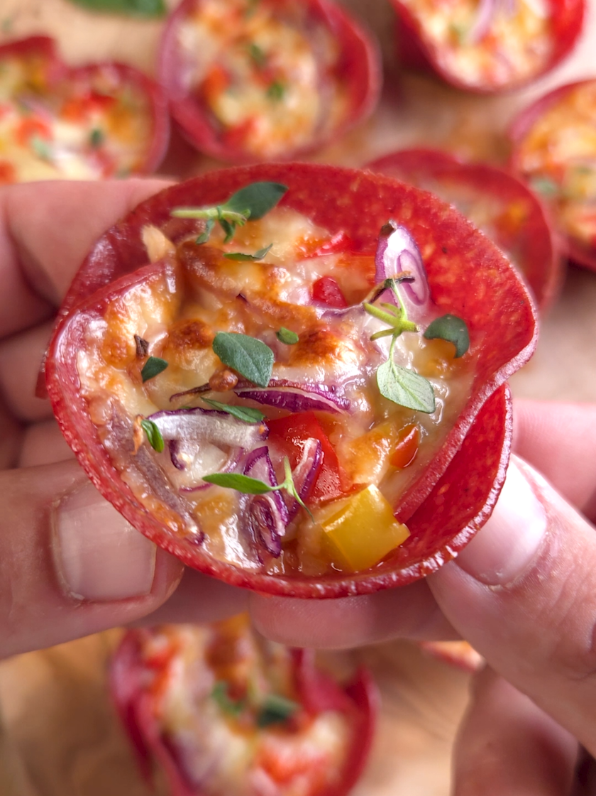 Salami Pizza Cups. Kleine Pizzasnacks aus knuspriger Salami, gefüllt mit Tomatensauce, Käse und buntem Gemüse. Perfekt für Party oder Snack zwischendurch. Zutaten: - Salami (große Scheiben) - Passierte Tomaten - Basilikum - Salz, Pfeffer - Oregano - Streukäse - Paprika (rot und gelb) - Rote Zwiebel Zubereitung: 1. Salamischeiben mehrfach seitlich einschneiden und in eine Muffinform drücken.   2. Tomatensauce aus passierten Tomaten, Basilikum, Salz, Pfeffer und Oregano anrühren und in die Cups füllen.   3. Mit Käse bestreuen, dann Paprika und Zwiebeln darauflegen.   4. Noch einmal mit Käse toppen.   5. Bei 200°C ca. 12 Minuten im Ofen backen.   6. Mit frischem Basilikum garnieren und servieren.   #snackideen #fingerfood #partyfood #schnellerezepte 