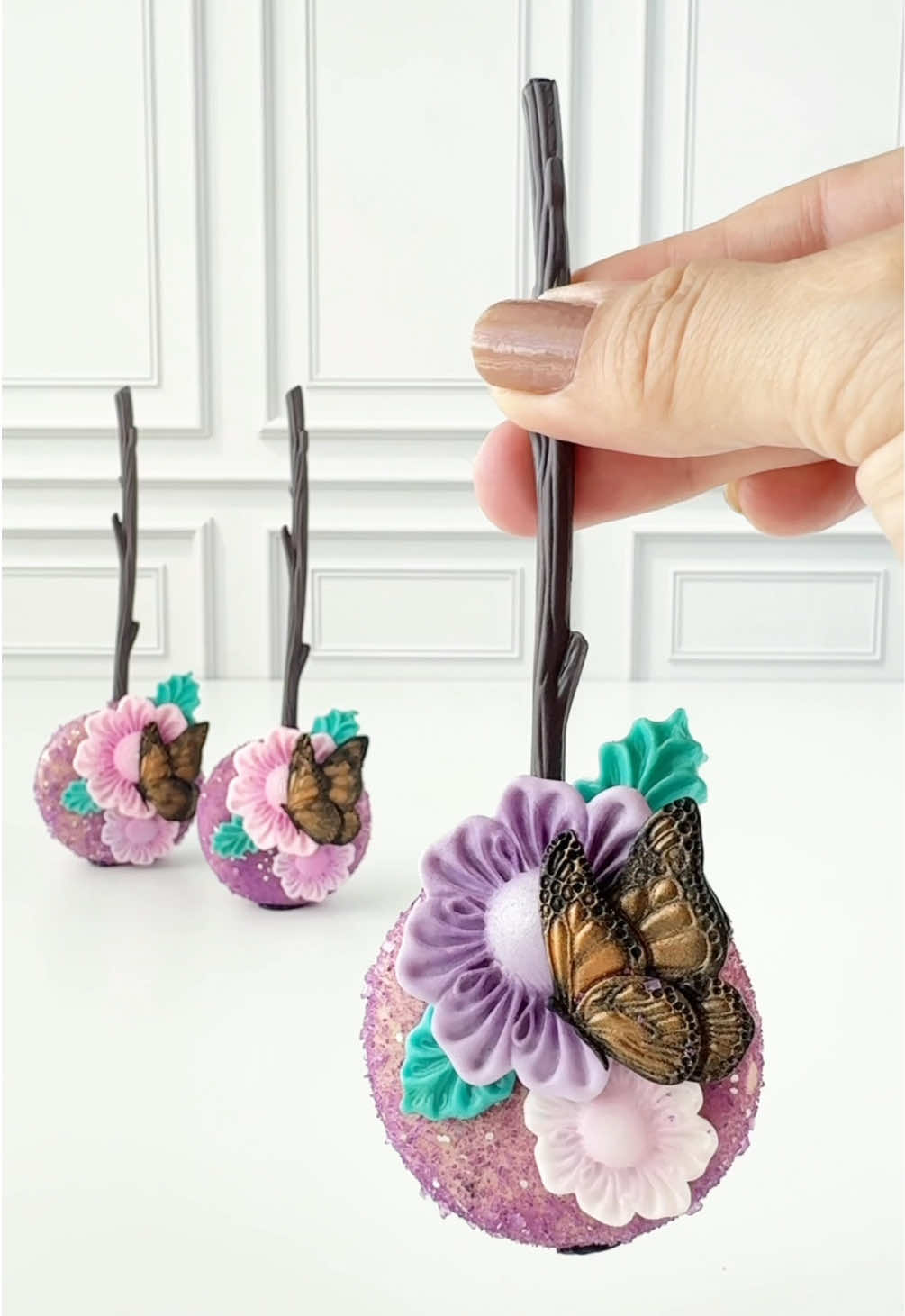 Every sparkle, every pop… crafted golden when you create with the right essentials. 💜✨  Branch sticks, flower + butterfly molds: @Sugary Essentials Corp Glittery sugar: @Bakery Bling Metallic lustre: @Sweet Sticks Cakepop disc mold: @My Little Cakepop #cakepops #edibleart#cakedecoratingeations #cakedecorating