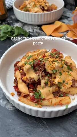 Nacho  Taco Beef Cheesy Sauce Pasta 😍 Beef cooked with taco seasoning, onions, peppers and tomatoes, tossed through pasta and drizzled with a quick double cheese sauce. Finished with fresh coriander and crushed tortilla chips for extra crunch 🫶🏼 A high protein, easy weeknight dinner that’s ready in under 30 minutes 🙌🏼 Want more recipes like this? Grab my cookbook “Low-Cal Kitchen Bangers” that’s got 100 more delish easy recipes. Links in my bio 🫶🏼 Ingredients (serves 2): 120g dry pasta  200g lean beef mince  1 white onion diced  1 red pepper diced 1 tsp chopped garlic  1 tbsp taco seasoning 1 tbsp tomato purée 200g chopped tomatoes  150ml pasta water  2 sprigs of fresh coriander finely chopped  3-4 tortilla chips crushed (I used Cheese)  Double Cheese Sauce: 10g lighter spread (I used Flora) 10g plain flour  150ml semi-skimmed milk warmed  ½ tsp smoked paprika  25g half fat cheddar grated  10g red leicester cheese grated (can sub more cheddar)    💕Start by bringing the pasta to boil in a large pan of salted water. Cook according to packet instructions. Drain and set aside.   💕Add the beef mince to a large pan and fry for 3-4 minutes until almost browned.  💕Once the beef is almost browned, add the white onion and pepper. Cook for a few more minutes until soft.   💕Stir in the chopped garlic for a minute before adding the taco seasoning, tomato puree and chopped tomatoes. Pour in the pasta water and turn the heat down to low to thicken.  💕Heat a saucepan over medium heat. Add the butter until melted before stirring in the flour to make a roux. Cook for a minute and gradually whisk in the milk until smooth. 💕Once smooth, season with the smoked paprika and add the cheeses. Stir until smooth.  💕Add the pasta into the beef and toss to combine.  💕Serve the pasta before pouring over the cheesy sauce.  💕Garnish with the fresh coriander and crumble over the tortilla chips.   Calories per portion: 561 l Protein: 41.5g l Fat: 13.3g l Carbs: 64.3g  . . ________ #pastarecipes #comfortfood   #dinnerrecipes #highproteindinner #EasyRecipes 