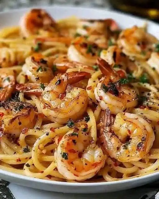 garlic shrimp pasta Ingredients: 1 lb large shrimp, peeled and deveined 8 oz spaghetti (or your favourite pasta) 3 tbsp olive oil 4 cloves garlic, minced 1/2 tsp red pepper flakes (optional for a little heat) 1/2 cup chicken broth (or white wine) 1/2 cup heavy cream 1/4 cup grated Parmesan cheese Salt and pepper, to taste Fresh parsley, chopped, for garnish Lemon wedges, for serving Instructions: Cook the pasta:  Cook the spaghetti according to the package directions. Drain and set aside, reserving about 1/2 cup of pasta water. Sauté the shrimp:  Heat olive oil in a large skillet over medium heat. Add the shrimp, seasoning with salt and pepper. Cook for about 2-3 minutes per side until the shrimp is pink and cooked through. Remove the shrimp from the skillet and set aside. Make the garlic sauce:  In the same skillet, add the minced garlic and red pepper flakes (if using), and sauté for about 30 seconds until fragrant. Pour in the chicken broth (or wine), scraping any bits from the bottom of the pan. Let the liquid reduce  slightly, about 2 minutes. Cream it up:  Stir in the heavy cream and bring it to a gentle simmer. Add the Parmesan cheese and continue to cook, stirring occasionally, until the sauce thickens, about 3 minutes. Combine pasta and shrimp: Add the cooked pasta to the skillet, tossing to coat in the creamy sauce. Add the cooked shrimp back in and toss again, adding pasta water if the sauce needs thinning. Serve:  Serve the pasta with a sprinkle of fresh parsley and a squeeze of lemon juice. Enjoy! Let this pasta do the job satisfactorly😛 #international #shellfish