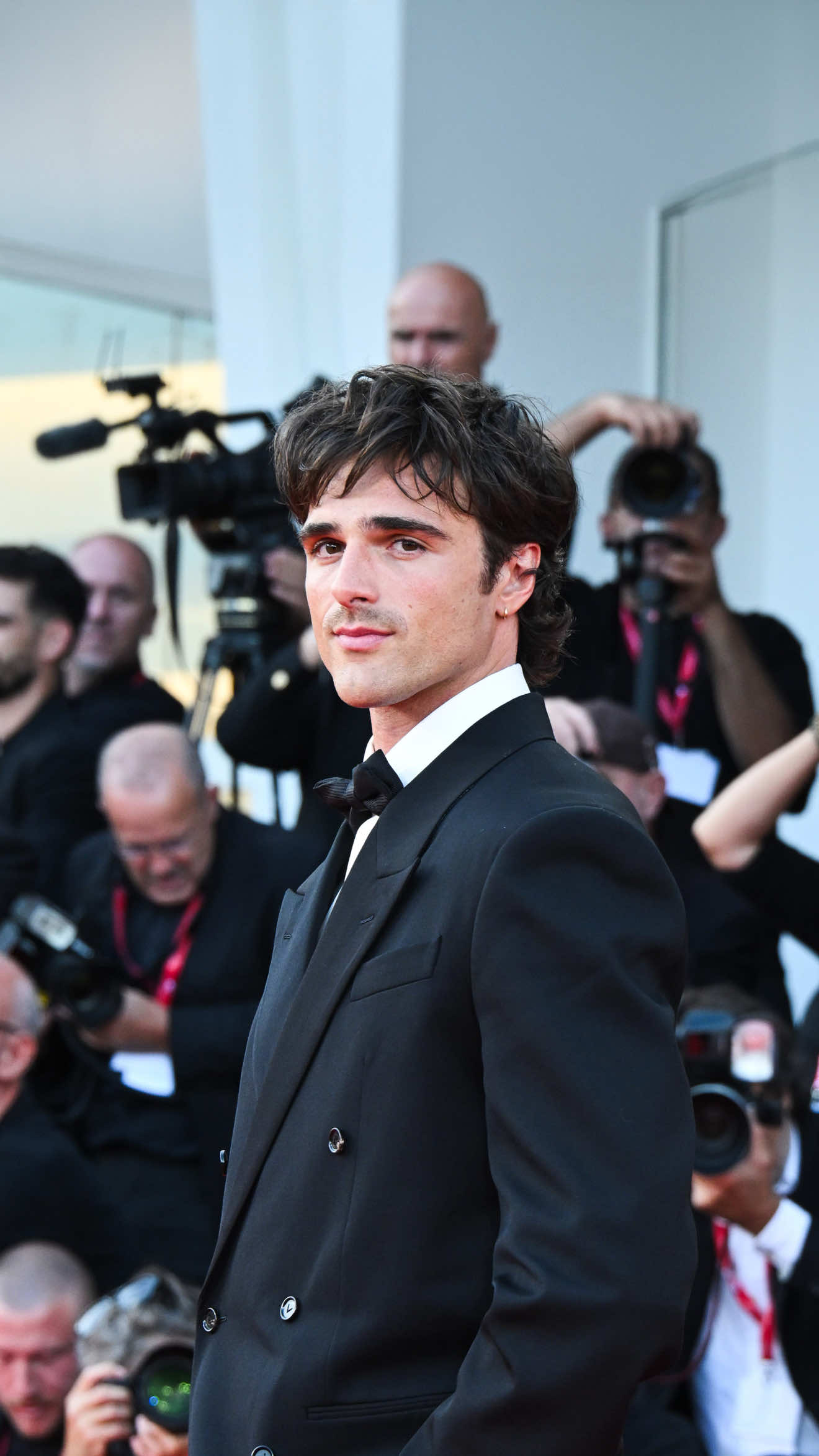 In conferenza stampa Jacob Elordi ha detto che i mostri del mondo reale sono “gli uomini in giacca e cravatta”. Riferimento con diverse letture che esulano dal mero punto di vista stilistico, a cui però lui, da quando è arrivato a Venezia, ha tenuto fede. Lo abbiamo visto anche sul red carpet di “Frankenstein”, film di Guillermo del Toro di cui è uno dei protagonisti principali. Con il suo fascino e la self confidence che lo contraddistingue, si è palesato facendo esplodere di gioia i fan appostati fuori dal Palazzo del Cinema del Lido.  Probabilmente incantati anche dal suo look, rigorosamente senza cravatta ma con il papillon. Abbinato a un suit sartoriale impeccabile nella sua struttura squadrata, powerful ed elegantemente contemporanea. Jacob completa il tutto con occhiali aviator e flat shoes in pelle con punta squadrata, tutto Bottega Veneta. Vi piace? ————————— At the press conference, @jacobelordi said that the real-world monsters are “men in suits and ties”. A remark open to many interpretations beyond the merely stylistic one, but one to which he has, since arriving in Venice, remained faithful. We also saw him on the red carpet of “Frankenstein”, Guillermo del Toro’s film in which he plays one of the main roles. With his charm and the self-confidence that distinguishes him, he appeared and set off an explosion of joy among the fans waiting outside the Palazzo del Cinema at the Lido. Probably enchanted also by his look, strictly without a tie but with a bow tie. Paired with a sartorial suit impeccable in its squared structure, powerful and elegantly contemporary. Jacob completed it all with aviator sunglasses and flat leather shoes with a squared toe, all by Bottega Veneta. Do you like him? [📸 IPA] #whoopsee #jacobelordi #frankenstein #venezia82 