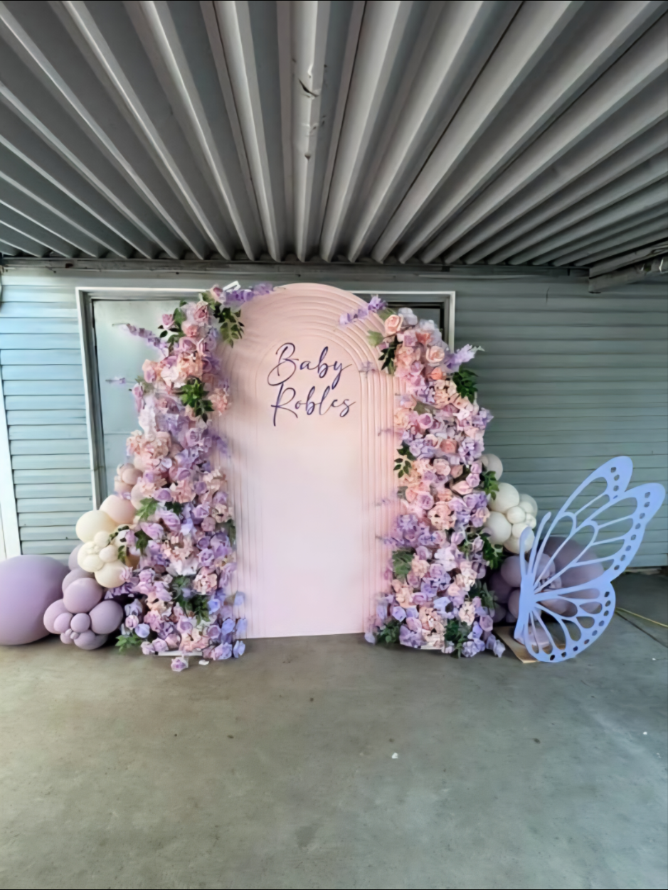How stunning is this ripple wall backdrop with the added florals? The small balloon garlands add the perfect finishing touch to the setup, and the butterfly cutout makes it even more adorable. Absolutely beautiful!