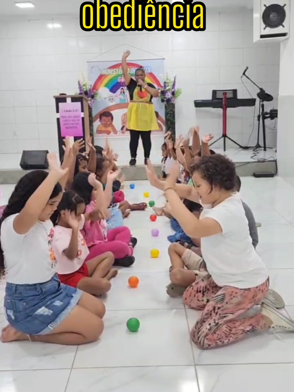 A ludicidade na aplicação da palavra de Deus. #ministerioinfantil  Dinâmica  para explicar sobre a obediência aos mandamentos de Deus, aos pais , aos professores e aos líderes espirituais. Pois através da bri#ncadeira podemos levar a criança a entender que assim como obedecem aos comandos da dinâmica , elas devem também obedecer a palavra de Deus, aos pais e aos seus mestres, etc.  COMO BRINCAR:  1° Organiza-se duas fileiras de crianças, uma de frente para a outra , todas sentadas no chão de pernas cruzadas. 2° Com alguns centímetros de distância uma criança da outra , coloca-se no meio delas uma bolinha de piscina ou pode ser uma bolinha de papel ou até mesmo uma tampinha de refrigerante. 3° Na sequência, será dado alguns comandos às crianças, da qual elas deverão parar para ouvir e depois executar, por exemplo, quando o professor (a) falar: 